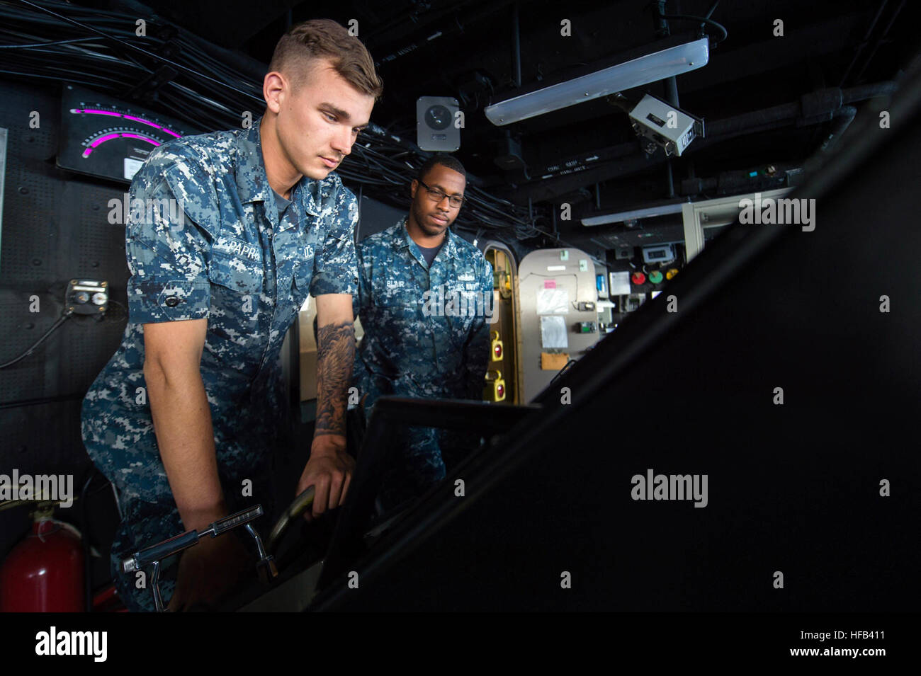 PACIFIC OCEAN (March 23, 2015) Boatswain's Mate Seaman Raymond Paprota, from Monroe, N.J., left, and Boatswain's Mate 3rd Class Keith Blair, from Memphis, Tenn., steer the San Antonio-class amphibious transport dock ship USS Anchorage (LPD 23) during a simulated strait transit. Anchorage is underway participating in a Composite Training Unit Exercise (COMPTUEX) with the Essex Amphibious Ready Group (ARG), which is comprised of Amphibious Squadron (PHIBRON) THREE and 15th Marine Expeditionary Unit (MEU). (U.S. Navy photo by Mass Communication Specialist 3rd Class Liam Kennedy/Released) COMTUEX  Stock Photo