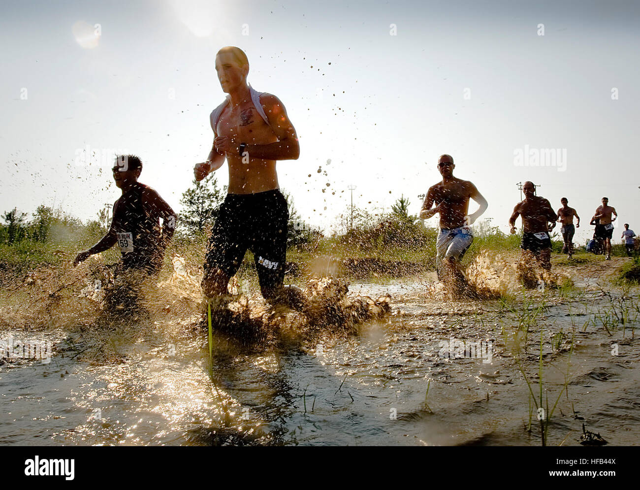 Runners step though water and mud during the 10th annual Armed Services