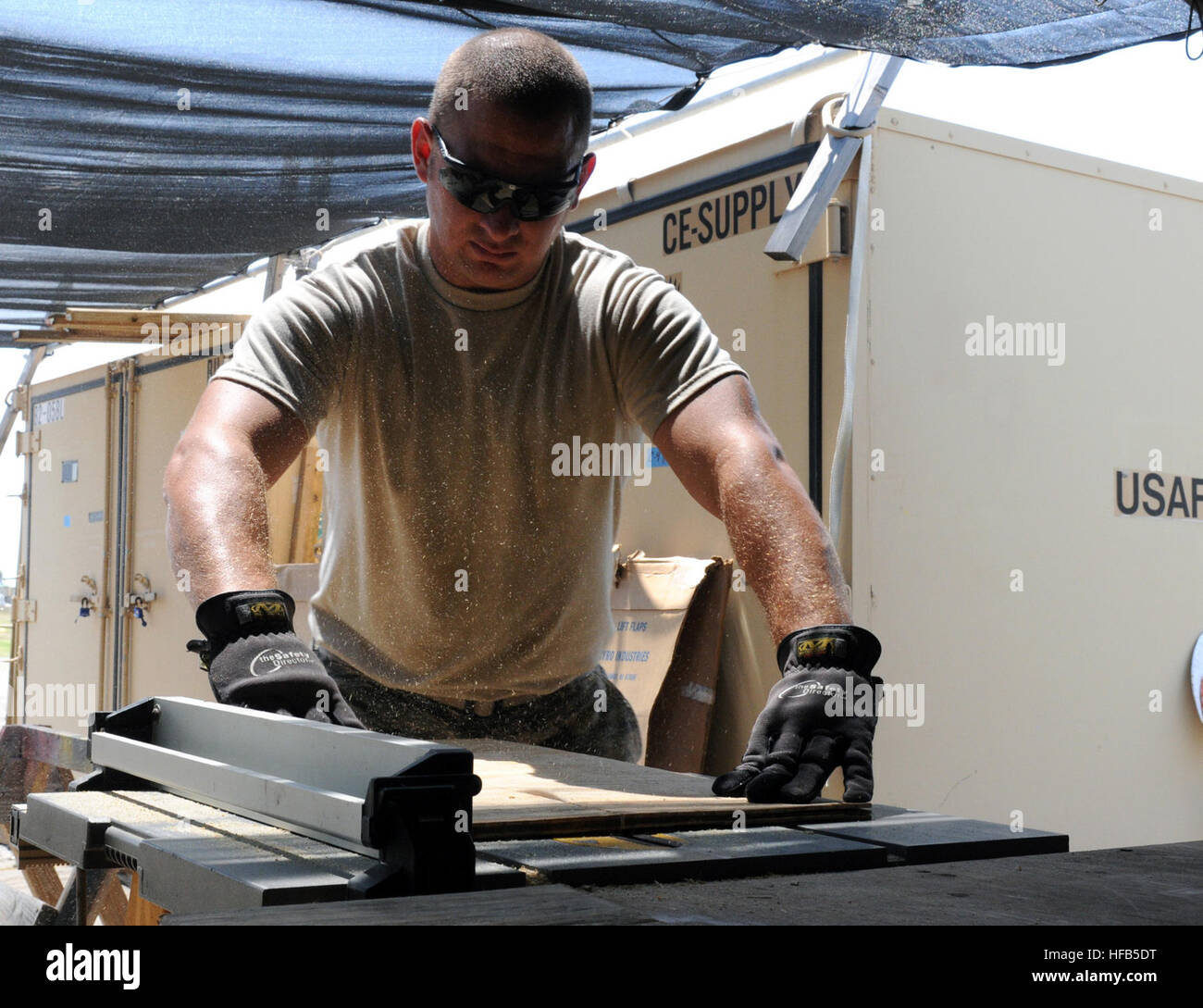 GUANTANAMO BAY, Cuba – Air Force Staff Sgt. Gary Learmonth, of the 474th Expeditionary Civil Engineering Squadron, Base Emergency Engineer Force, Joint Task Force Guantanamo, measures a piece of plywood before sawing it in Camp Justice, March 16, 2010. The 474th ECES maintains the Expeditionary Legal Complex, vital to the JTF mission. JTF Guantanamo conducts safe, humane, legal and transparent care and custody of detainees, including those convicted by military commission and those ordered released by a court. The JTF conducts intelligence collection, analysis and dissemination for the protect Stock Photo