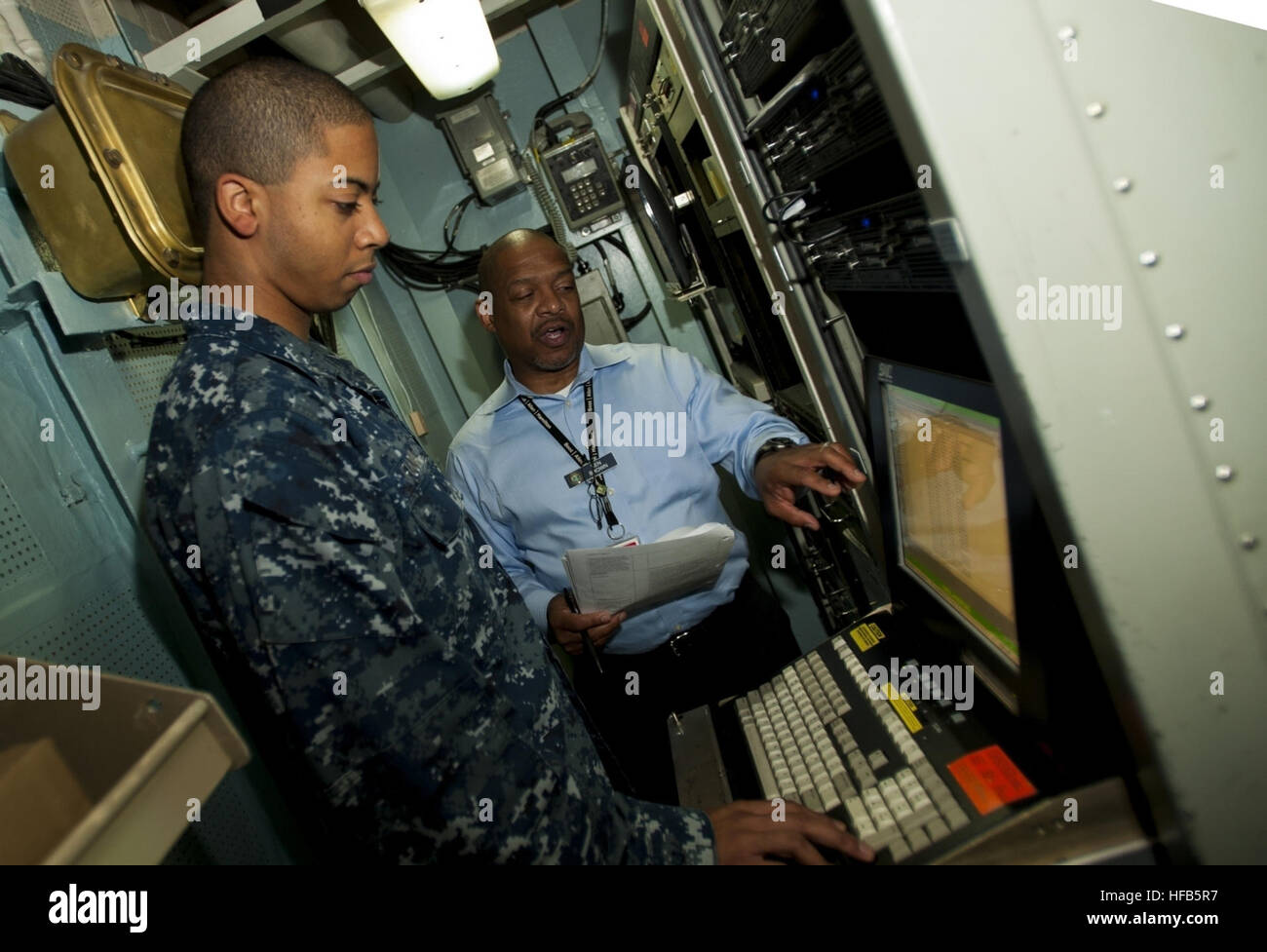 Ken Brown, assigned to Navy Cyber Forces, discusses shipboard computer applications with Information Systems Technician 2nd Class Rocky Fuqua aboard the guided-missile destroyer USS Ross (DDG 71). (U.S. Navy photo by Robin Hicks/Released). Cyber Forces discussion 130820-N-XS652-037 Stock Photo