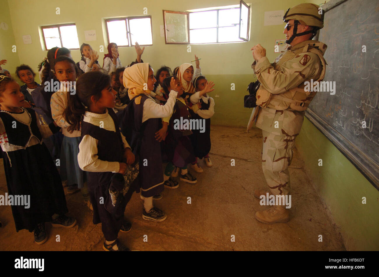 050322-N-5319A-015 U.S. Army Chaplin Tommy Fuller takes a photo of Iraqi school children at the Al Mutnba Primary School located near Camp Kalsu, Iraq, on March 22, 2005.  Members of the155th Brigade Combat Team from Tupelo, Miss., are delivering school supplies under a Fuller-initiated Adopt a School program aboard Camp Kalsu where different units choose a local school and try to connect them with a U.S. school to help with supplies and start a pen pal program.  DoD photo by Petty Officer 1st Class Brien Aho, U.S. Navy.  (Released) Defense.gov News Photo 050322-N-5319A-015 Stock Photo