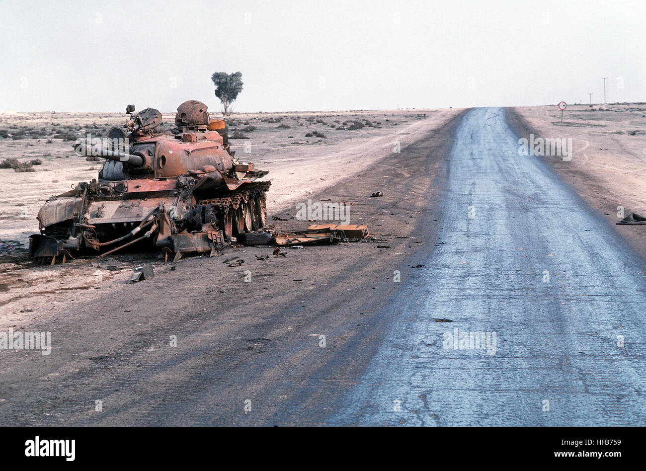 A destroyed Iraqi T55 main battle tank lies abandoned beside a road at