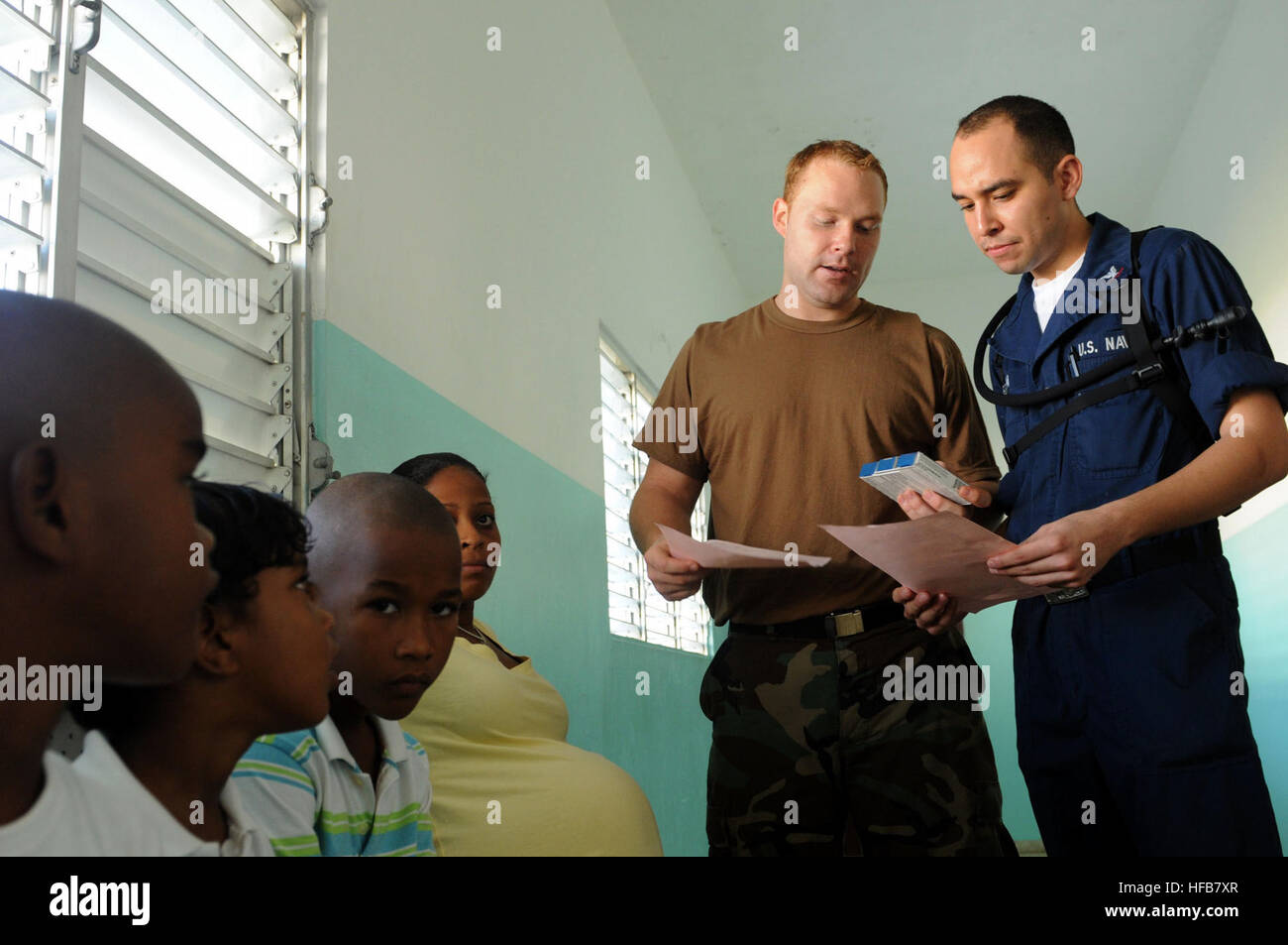 Shane Leidig, hospital corpsman, and Petty Officer 2nd Class Rogelio Heredia, embarked aboard the amphibious assault ship USS Kearsarge, discuss prescription instructions with a Dominican family at the Don Diego Pier medical facility. Kearsarge is the primary platform for the Caribbean phase of the Continuing Promise 2008 humanitarian assistance mission, an equal-partnership mission involving the United States, Canada, the Netherlands, Brazil, France, Nicaragua, Colombia, Dominican Republic, Trinidad and Tobago and Guyana. Don Diego Pier Medical Facility 122495 Stock Photo