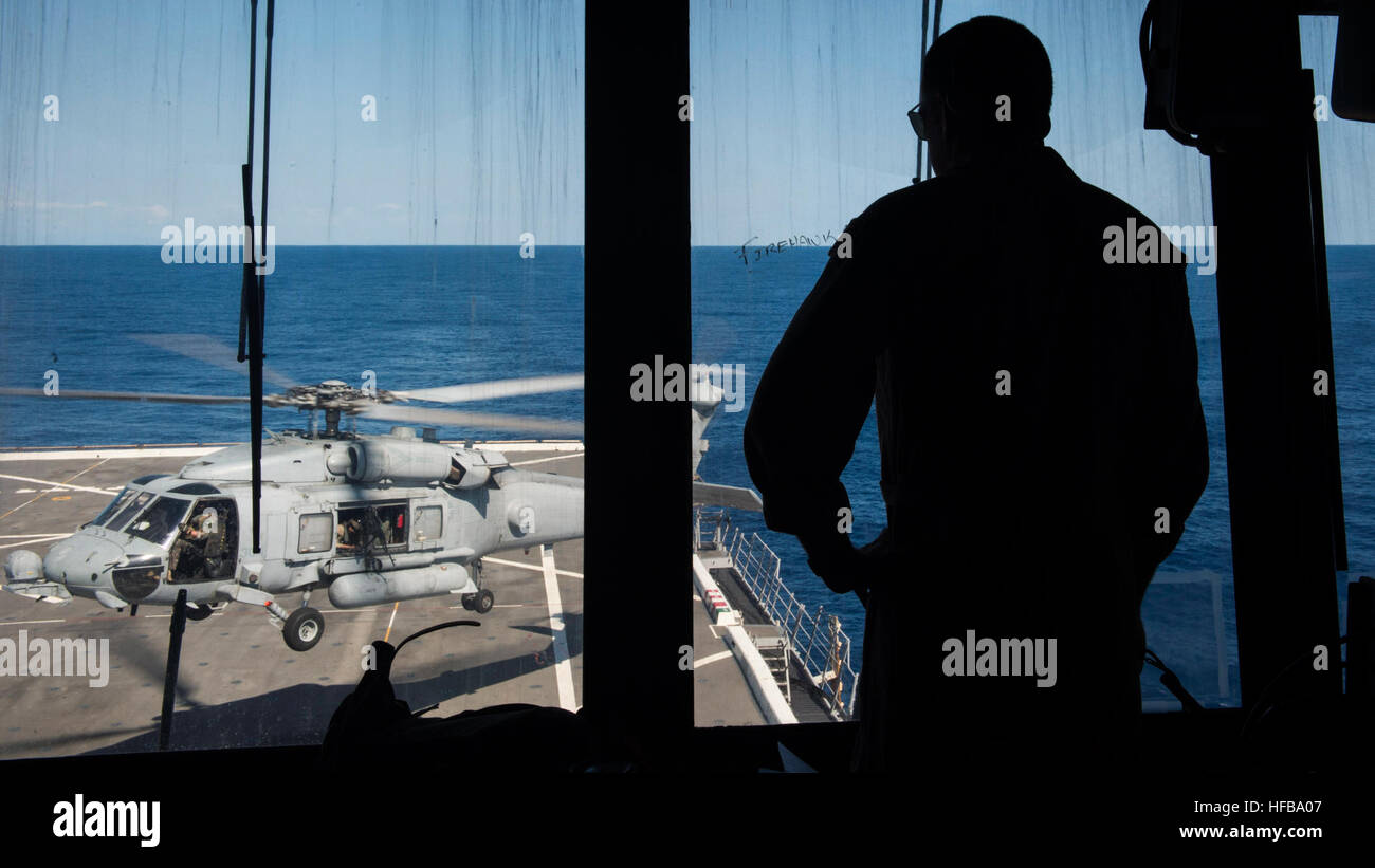 150423-N-KE519-005 PHILIPPINE SEA (April 23, 2015) - Lt. Cmdr. Mason Berry monitors flight operations aboard the amphibious transport dock ship USS Green Bay (LPD 20). Green Bay is part of the Bonhomme Richard Amphibious Ready Group and, with the embarked 3rd Marine Expeditionary Force Forward, is currently participating in Exercise Balikatan 2015. (U.S. Navy photo by Mass Communication Specialist 3rd Class Edward Guttierrez III/Released) Exercise Balikatan 2015 150423-N-KE519-005 Stock Photo