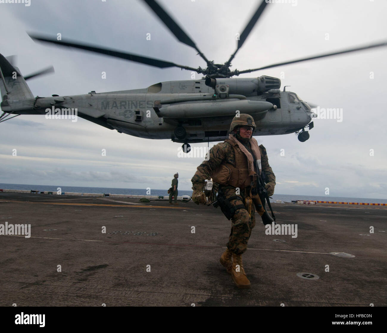 A Marine assigned to 15th Marine Expeditionary Unit moves to safety ...