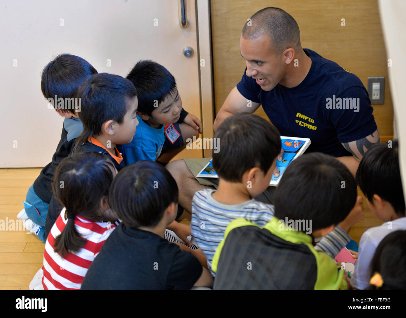 160627-N-OK605-010 MISAWA, Japan (June 27, 2016) Information Sytems Technician 1st Class Ryan McNair, attached to Naval Air Facility Misawa (NAFM), from Gulfport, Miss., practices english with the children at the Ohzora Jido-Kan, a Japanese after school care center. Sailors from NAFM volunteer to make bi-weekly visits to the after school care center as part of community relations efforts. (U.S. Navy Photo by Mass Communication Speciliast 2nd Class Samuel Weldin/Released) 160627-N-OK605-010 160627-N-OK605-010 Stock Photo