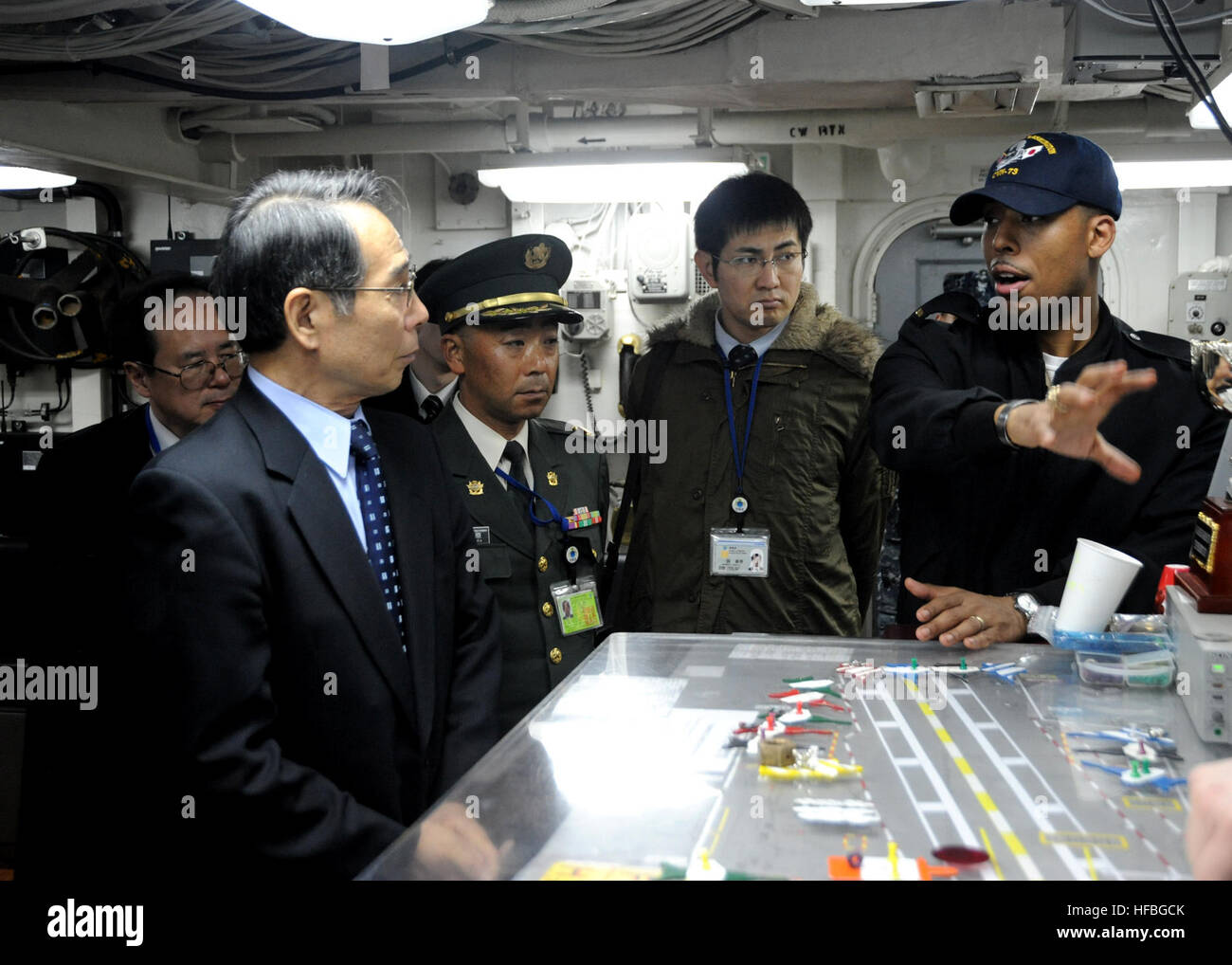 120301-N-ZT599-195 YOKOSUKA, Japan (March 01, 2012) Ensign Derrick Ingle gives Hisashi Kajiki, Inspector General of the Japanese Ministry of Defense, and his staff a tour of flight deck control aboard the Nimitz-class aircraft carrier USS George Washington. The guests were also able to tour the George Washington's hangar bay, navigation bridge and flight deck. George Washington is the Navy's only full-time forward-deployed aircraft carrier ensuring security and stability in the western Pacific Ocean. (U.S. Navy photo by Mass Communication Specialist Seaman Apprentice Brian H. Abel/Released)  - Stock Photo