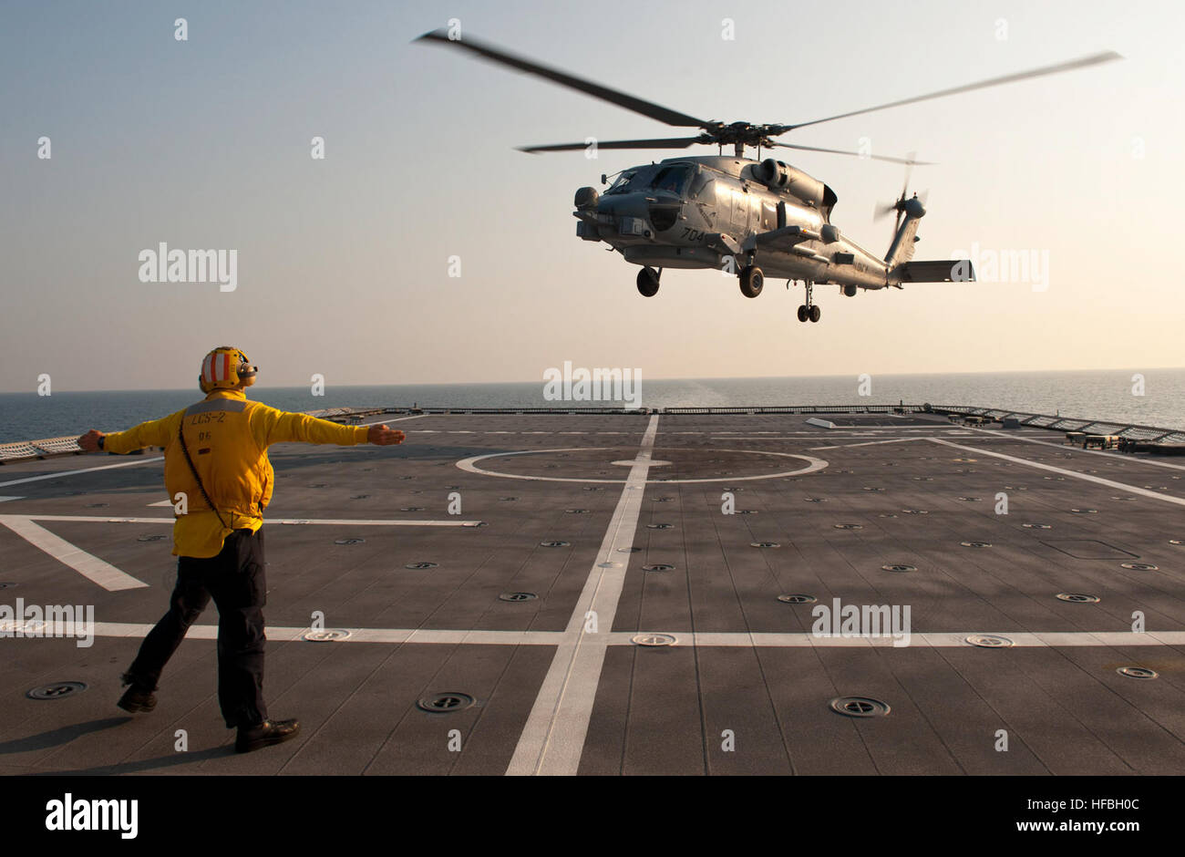 120409-N-ZS026-514 ATLANTIC OCEAN (April 9, 2012) Boatswain’s Mate 3rd Class Robert Chittenden signals for an MH-60R Sea Hawk helicopter assigned to the Swamp Foxes of Helicopter Maritime Strike Squadron (HSM) 74 to take off from the flight deck of the littoral combat ship USS Independence (LCS 2). Sailors from Independence's Gold crew and embarked Mine Countermeasures Detachment 1 are underway for the ship's transit to San Diego after successfully completing testing on the mine countermeasures mission package. (U.S. Navy photo by Mass Communication Specialist 2nd Class Trevor Welsh/Released)  Stock Photo