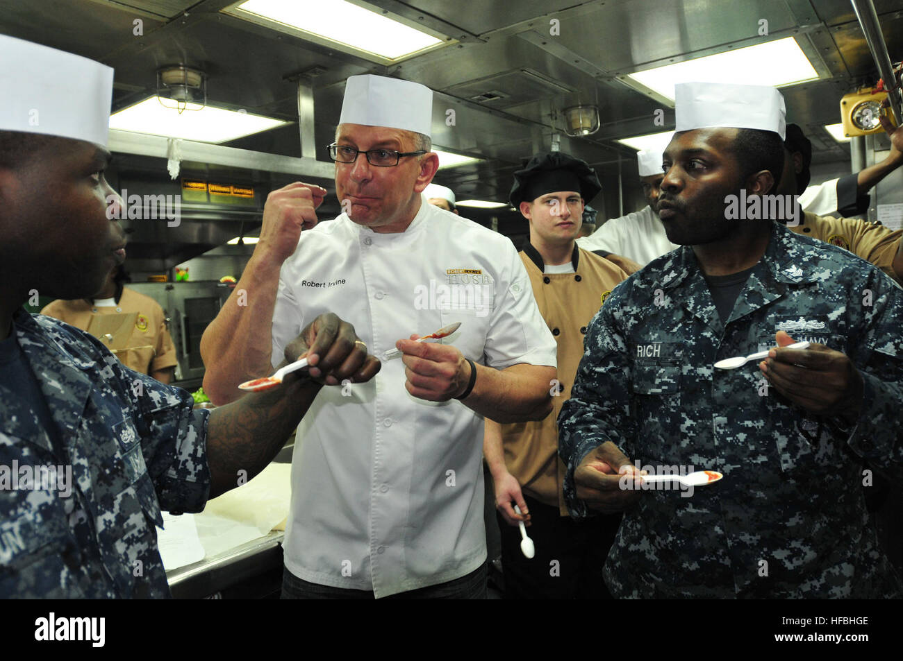 MAYPORT, Fla. (Oct. 23, 2012) Food Network Chef Robert Irvine talks with Culinary Specialist 1st class Romonn Calhoun, left, and Culinary Specialist 1st class Ladale Rich about the importance of tasting a dish while your making it during a cooking lesson aboard the guided-missile destroyer USS The Sullivans (DDG 68). Irvine is visiting several ships stationed at Naval Station Mayport. (U.S. Navy photo by Mass Communication Specialist 1st Class John Parker/Released) 121023-N-BB308-146  - Official U.S. Navy Imagery - Chef Robert Irvine talks with Navy cooks. Stock Photo