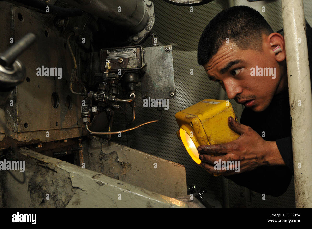 110406-N-NL541-091 CARIBBEAN SEA (April 6, 2011) Engineman 2nd Class Justin Davila, assigned to the guided-missile frigate USS Boone (FFG 28), uses a flashlight to inspect a service diesel generator. Boone is deployed in support of Southern Seas 2011. (U.S. Navy photo by Mass Communication Specialist 3rd Class Stuart Phillips/Released)  - Official U.S. Navy Imagery - Enginemen 2nd Class, Justin Davila inspects service diesel aboard the USS Boone Stock Photo