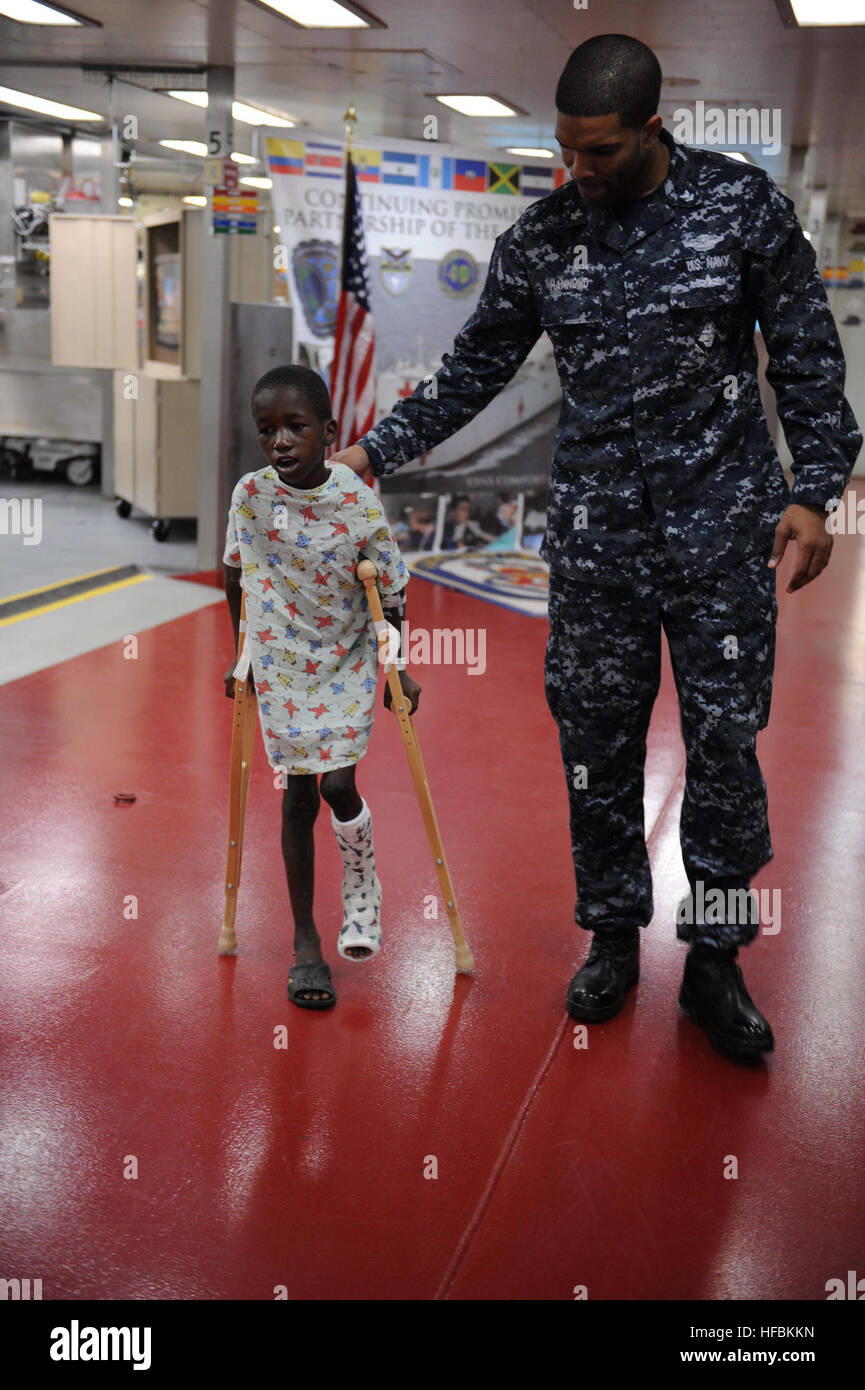 110417-F-NJ219-278 KINGSTON, Jamaica (April 17, 2011) Hospital Corpsman 3rd Class Lamonte Hammond, from Md., steadies a Jamaican boy learning to use his crutches after undergoing surgery to elongate his foot tendion aboard the Military Sealift Command hospital ship USNS Comfort (T-AH 20) during Continuing Promise 2011 (CP11). CP11 is a five-month humanitarian assistance mission to the Caribbean, Central and South America. (U.S. Air Force photo by Staff Sgt. Courtney Richardson/Released)  - Official U.S. Navy Imagery - Sailor-Md. native steadies a Jamaican boy learning to use crutches aboard US Stock Photo