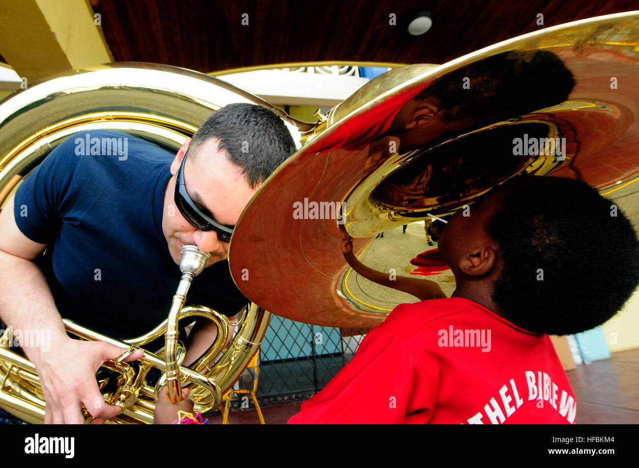 110414-N-EP471-311 KINGSTON, Jamaica (April 14, 2011) Musician 3rd Class Christopher Roland, from Oklahoma, plays his tuba for a Jamaican child during a Continuing Promise 2011 medical community service event at the National Sports Arena. Roland is embarked aboard the Military Sealift Command hospital ship USNS Comfort (T-AH 20) during the five-month humanitarian assistance mission to the Caribbean, Central and South American. (U.S. Navy photo by Mass Communication Specialist 1st Class Kim Williams/Released)  - Official U.S. Navy Imagery - Sailor-Oklahoma native plays his tuba for a Jamaican c Stock Photo