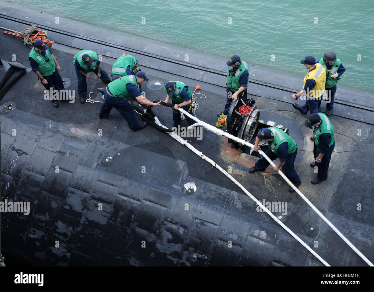 110520-N-GE301-049 HONG KONG (May 20, 2011) Sailors assigned to the Los Angeles-class fast attack submarine USS Hampton (SSN 767) handle lines as the submarine detaches from the submarine tender USS Frank Cable (AS 40). Hampton moored alongside Frank Cable during a port visit to Hong Kong. Frank Cable conducts maintenance and support of submarines and surface vessels deployed in the U.S. 7th Fleet area of responsibility. (U.S. Navy photo by Mass Communication Specialist 3rd Class Gabrielle Blake/Released)  - Official U.S. Navy Imagery - Sailors assigned to USS Hampton (SSN 767) handle lines as Stock Photo