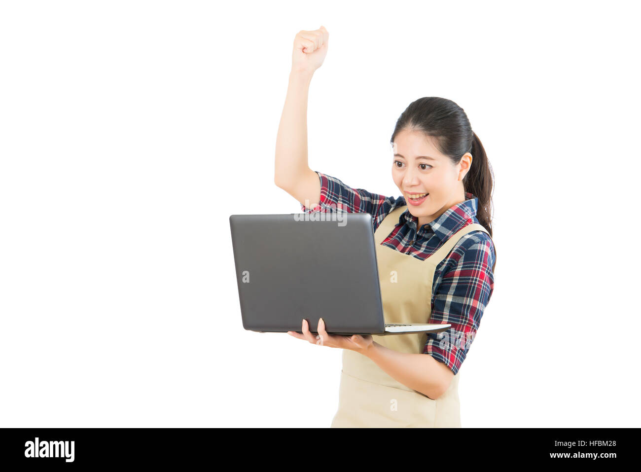 young housewife with apron using computer to research online successful ...