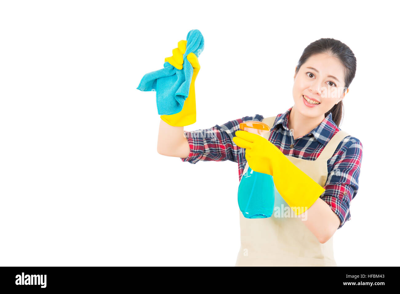 Housewife cleaning using the rag and bottle spray with rubber gloves. Pretty smiling young mixed race Asian girl isolated on white background. Stock Photo