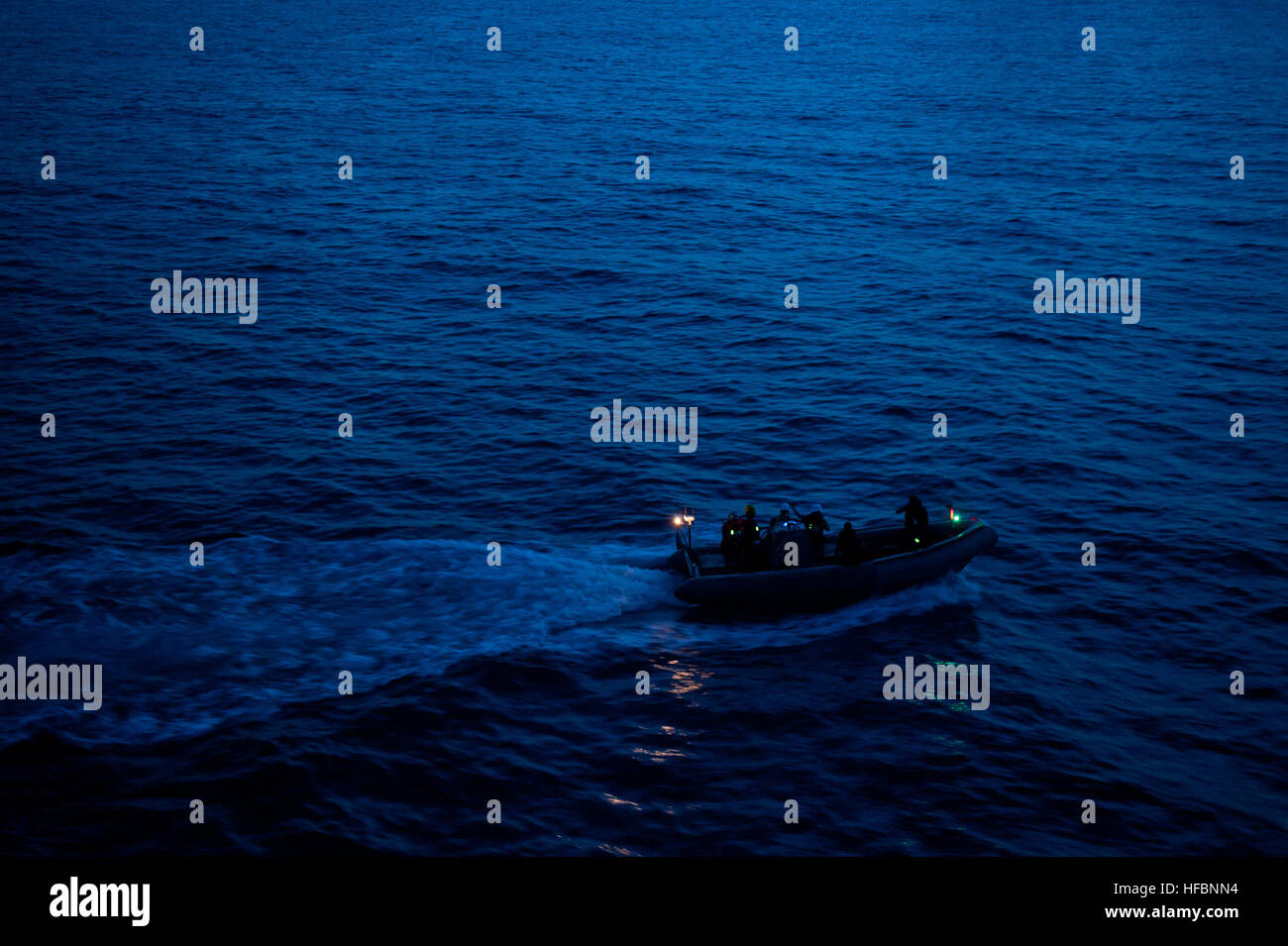 120907-N-TX154-206 PACIFIC OCEAN (Sept. 7, 2012) Sailors assigned to the Ticonderoga-class guided-missile cruiser USS Cowpens (CG 63) use a rigid hull inflatable boat to search for two recoverable exercise torpedoes that were launched by helicopters assigned to the Warlords of Helicopter Anti-Submarine Squadron Light (HSL) 51 just before sunset. Cowpens is part of the George Washington Carrier Strike Group and is conducting a routine western Pacific patrol. (U.S. Navy photo by Mass Communication Specialist 3rd Class Paul Kelly/Released) - Official U.S. Navy Imagery - Sailors search for two r Stock Photo