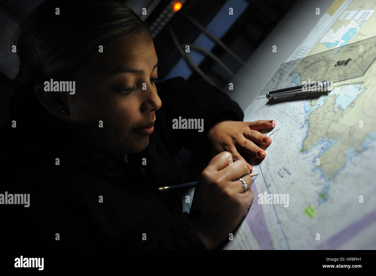 PACIFIC OCEAN (Sept. 29, 2012) Operations Specialist Seaman Jennifer Cloud, from Houston, Texas, plots points on a map in the commanding officerÕs tactical operation plot compartment aboard the aircraft carrier USS Nimitz (CVN 68). Nimitz is en route to San Diego to embark Carrier Air Wing 11 as it prepares for a composite training unit exercise. (U.S. Navy photo by Mass Communication Specialist Seaman Jess Lewis/Released) 120929-N-RX668-040 Join the conversation www.facebook.com/USNavy www.twitter.com/USNavy navylive.dodlive.mil  - Official U.S. Navy Imagery - Sailor marks a map. Stock Photo