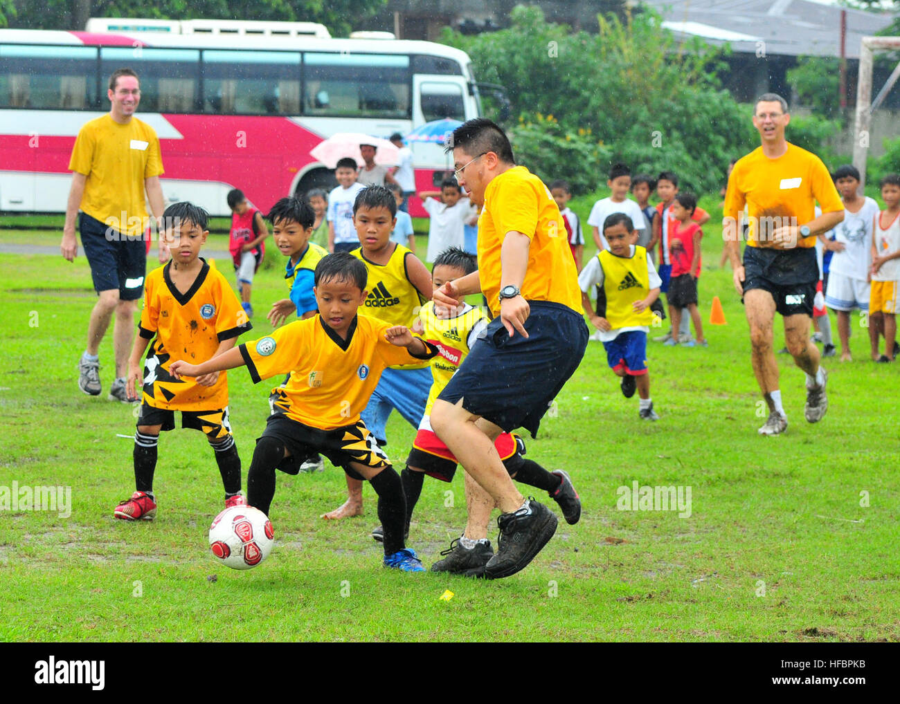 110730-N-BT122-037 OLONGAPO CITY, Philippines (July 30, 2011) Information Systems Technician 3rd Class Chi-Ming Chan, assigned to the submarine tender USS Frank Cable (AS 40), plays soccer against the Olongapo youth team during a community service event. Frank Cable conducts maintenance and support of submarines and surface vessels deployed in the U.S. 7th Fleet area of responsibility.  (U.S. Navy photo by Mass Communication Specialist 1st Class Melvin Nobeza/REleased)  - Official U.S. Navy Imagery - Sailor plays soccer against the Olongapo youth team. Stock Photo