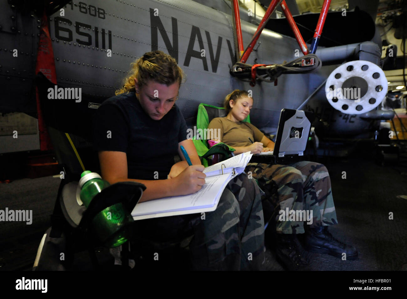 MEDITERRANEAN SEA (Sept. 19, 2012) Aviation Structural Mechanic 3rd Class Kalee McCulloch, left, works on her enlisted surface warfare specialist qualification as Aviation Machinist’s Mate Airman Kenzie Lane studies for her advancement exam in the starboard helicopter hangar aboard the guided-missile destroyer USS Jason Dunham (DDG 109). Jason Dunham is on a scheduled deployment in support of maritime security operations and theater security cooperation efforts in the 6th Fleet area of responsibility. (U.S. Navy photo by Mass Communication Specialist 2nd Class Deven B. King/Released) 120919-N- Stock Photo