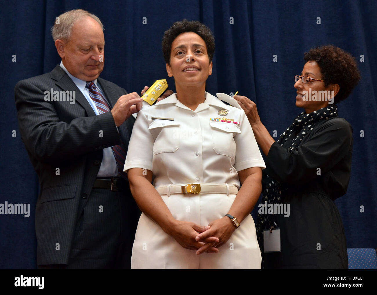 120824-N-QY430-030 NORFOLK (Aug. 24, 2012) Vice Adm. Michelle Janine Howard, center, has her shoulder boards replaced by her husband, Wayne Cowles and her sister, Lisa Teitleman, during a promotion ceremony at Naval Support Activity Hampton Roads. Howard is the first African-American woman to receive a third star in flag rank.  She assumes the duties as deputy commander of U.S. Fleet Forces Command and commander of Task Force 20. (U.S. Navy photo by Mass Communication Specialist 1st Class Rafael Martie/Released)  - Official U.S. Navy Imagery - Vice Adm. Howard is the first African-American wom Stock Photo