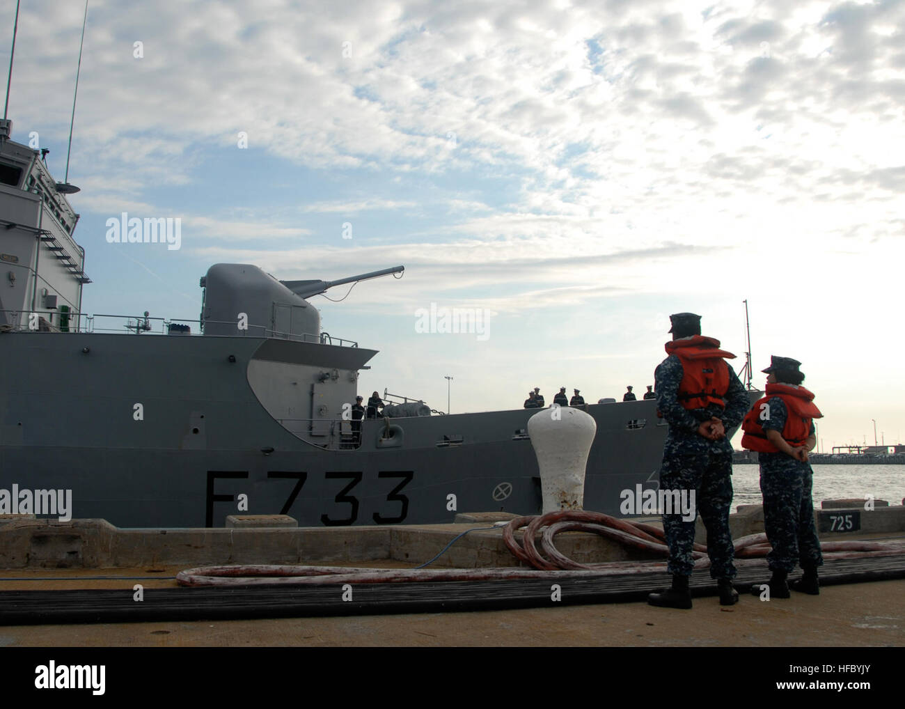 U.S. Navy sailors assigned to USS Ross wait to handle mooring lines as