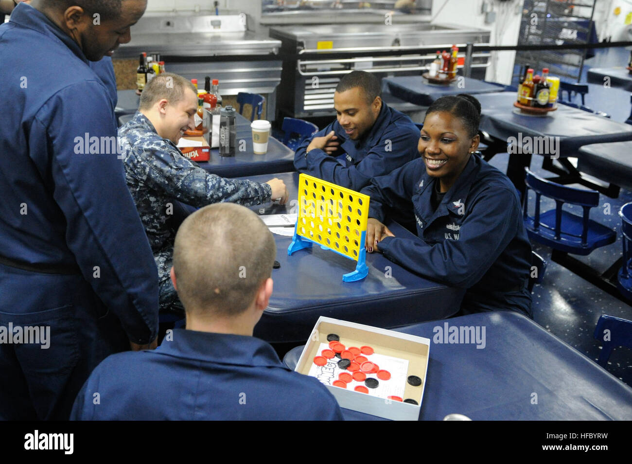 Sailors partake in a game of Connect 4 as part of a junior enlisted association (JEA) event aboard the amphibious assault ship USS Boxer (LHD 4). Boxer is the flagship for the Boxer Amphibious Ready Group and, with the embarked 13th Marine Expeditionary Unit (MEU), is deployed in support of maritime security operations and theater security cooperation efforts in the U.S. 5th Fleet area of responsibility. (U.S. Navy photo by Mass Communication Specialist Seaman Veronica Mammina/Released) Game night at sea 131022-N-GM561-086 Stock Photo