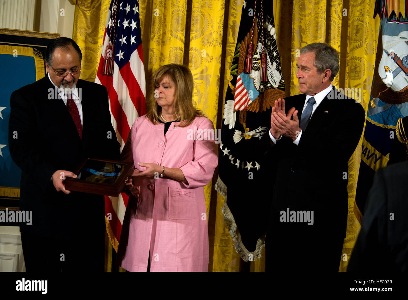 080408-N-5319A-006 WASHINGTON (April 8, 2008) George and Sally Monsoor look at the Medal of Honor presented to them in honor of their son by President George W. Bush Tuesday, April 8, 2008 during a ceremony in the East Room of the White House. Master-at-Arms 2nd Class (Seal) Michael A. Monsoor has been  posthumously awarded the Medal of Honor for diving onto a grenade to save his teammates in Ar Ramadi, Iraq on Sept. 29, 2006. Monsoor also received the Silver Star for his actions in May during the same deployment in 2006 when he exposed himself to heavy enemy fire to rescue and treat an injure Stock Photo