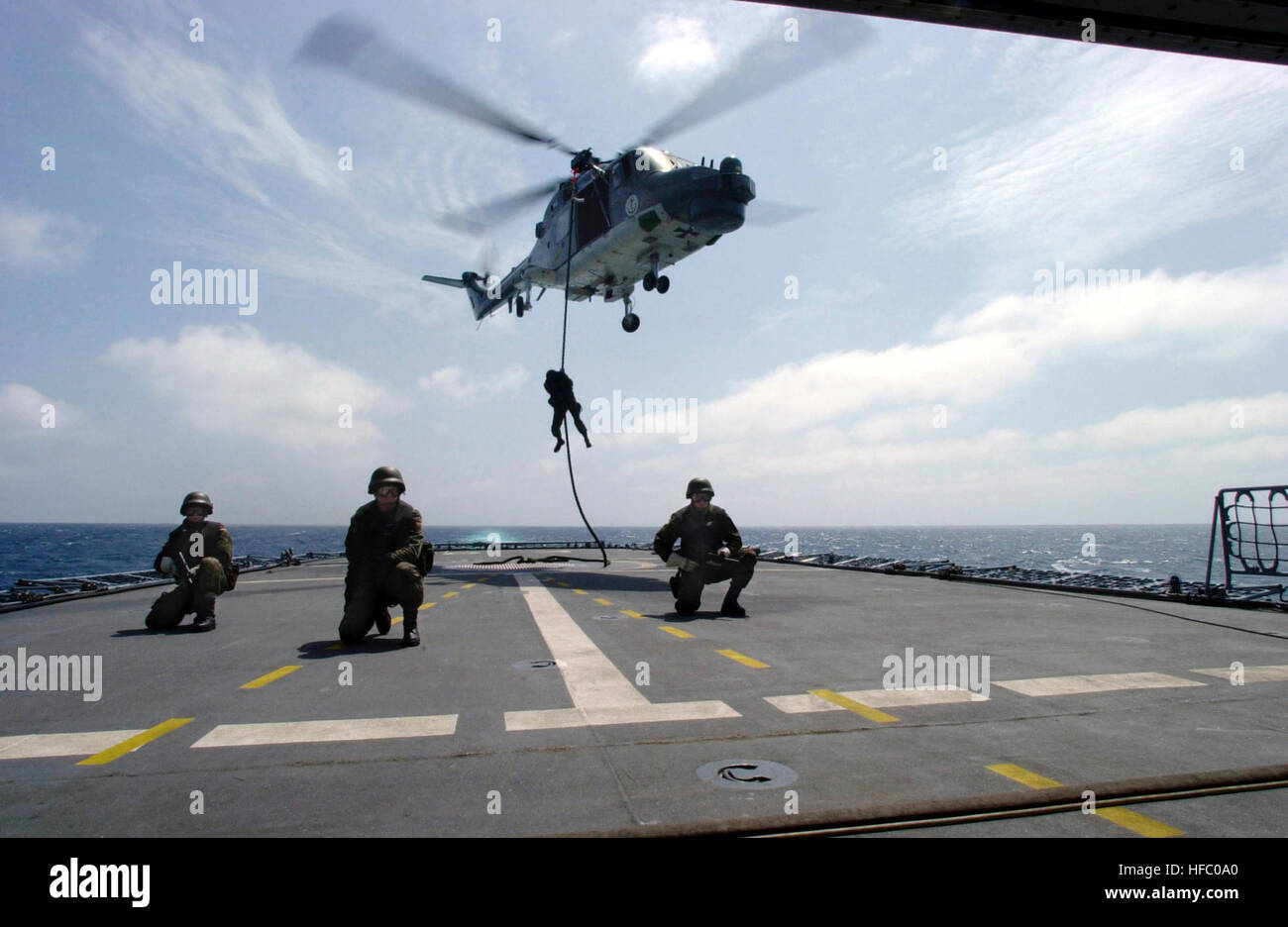 Fast roping from a Bundesmarine Westland Sea Lynx Mk-88 helicopter in the Gulf of Aden, a German Marine Regiment boards the FGS KOLN  (Bremen Class Frigate F 211) for some underway ship boarding tactics. The German frigate deployed to the gulf in support of Operation ENDURING FREEDOM. German soldiers fast rope from Sea Lynx on frigate Koeln (F211) 2002 Stock Photo