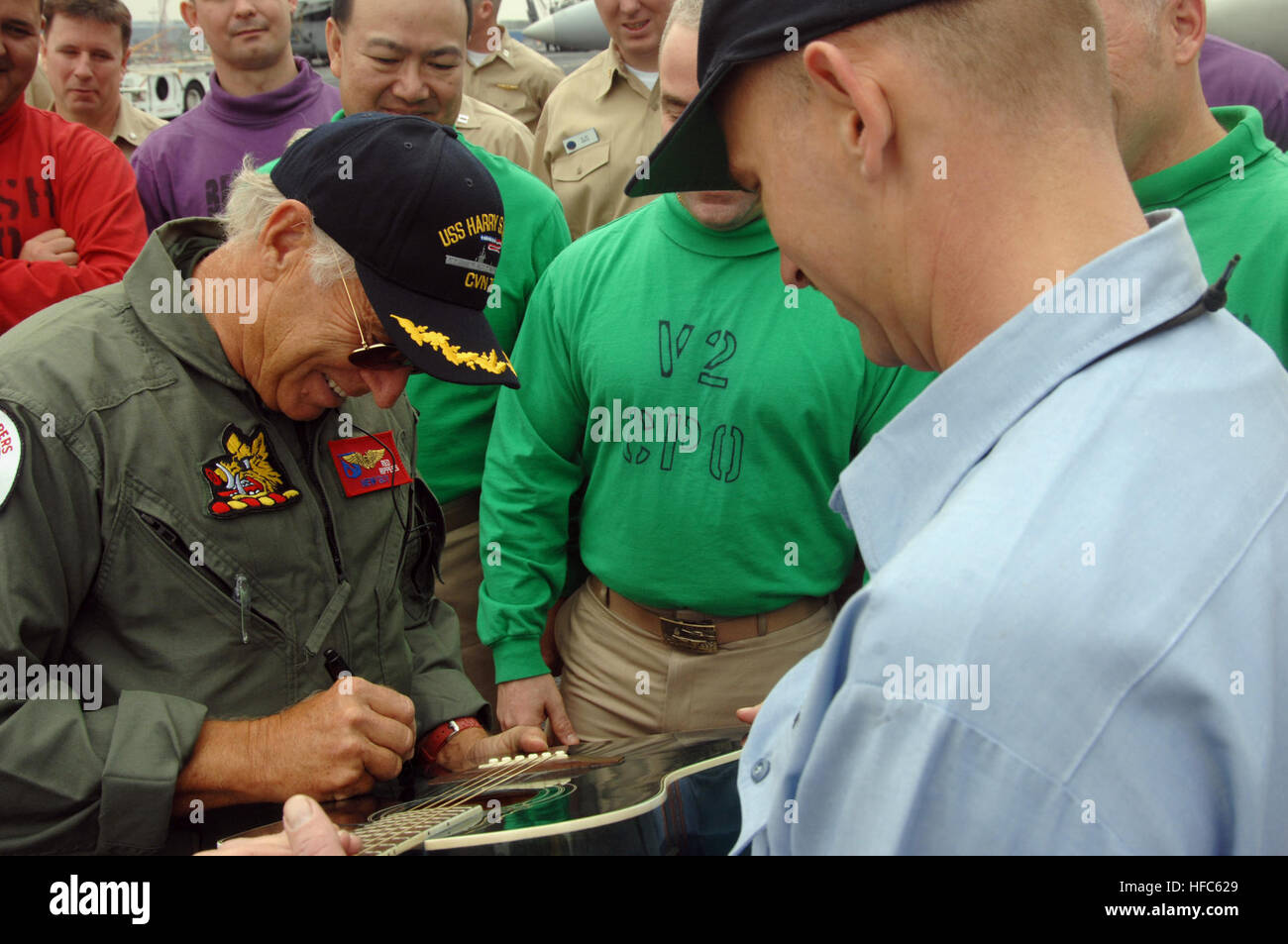 080128-N-8923M-035 MIDDLE EASTERN PORT (Jan. 28, 2008) Recording artist Jimmy Buffett autographs a Sailor’s guitar on the flight deck of the aircraft carrier USS Harry S. Truman (CVN 75) during a recent port visit in the Middle East. Truman and embarked Carrier Air Wing (CVW) 3 are on deployment in support of Operations Iraqi Freedom, Enduring Freedom and maritime security operations. U.S. Navy photo by Mass Communication Specialist Seaman Kevin T. Murray (Released) Jimmy Buffett autographs a Sailor's guitar 89459 Stock Photo