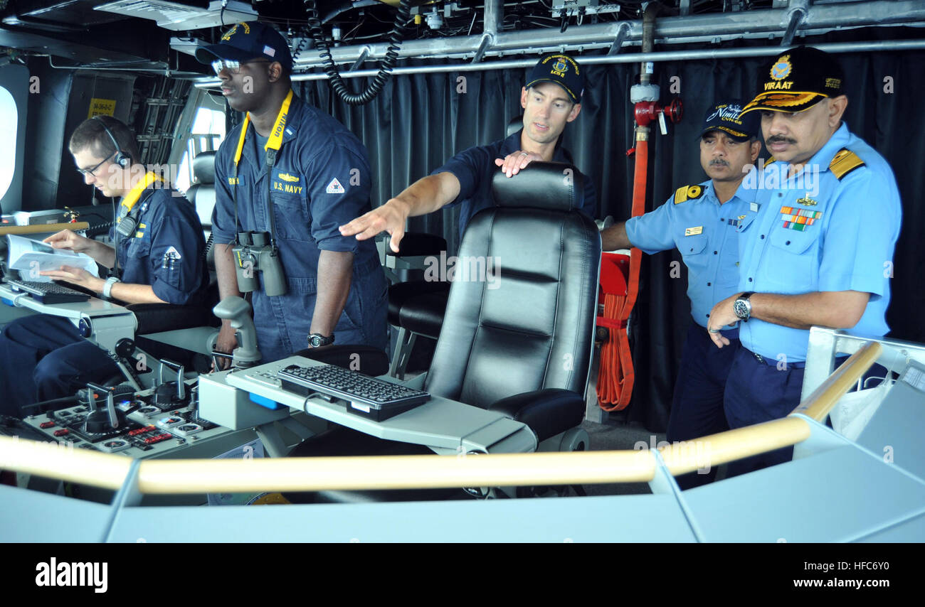 140713-N-UL721-221 PACIFIC OCEAN (July 13, 2014)  Cmdr. Joseph Gagliano, center, commanding officer of the littoral combat ship USS Independence (LCS 2) describes state-of-the-art features of the bridge during a ship tour for Rear Adm. Ajendra B. Singh, right, and Commodore Alok Bhatnagar from the Indian navy during Rim of the Pacific (RIMPAC) Exercise 2014. Twenty-two nations, more than 40 ships, six submarines, more than 200 aircraft and 25,000 personnel are participating in RIMPAC from June 26 to Aug. 1, in and around the Hawaiian Islands and Southern California. The world's largest maritim Stock Photo