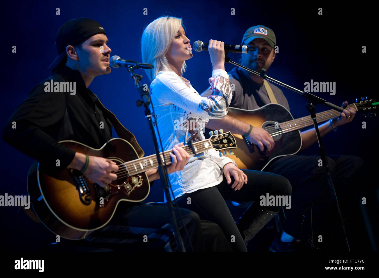 American Idol contestant and country musician Kellie Pickler and members of her band Joshua Henson, left, and Ryan Ochsner perform for U.S. service members during the first stop of the 2008 USO Holiday Tour on Ramstein Air Force Base, Germany, Dec. 16, 2008. The tour?s host, Chairman of the Joint Chiefs of Staff Navy Adm. Mike Mullen, and his wife Deborah joined Kid Rock; comedians John Bowman, Lewis Black and Kathleen Madigan; actress Tichina Arnold and Pickler on the tour to boost the morale of service members stationed overseas during the holiday season. (DoD photo by Mass Communication Spe Stock Photo