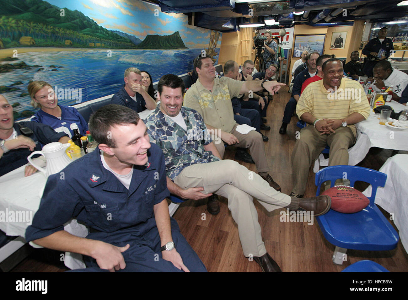 050206-N-3228G-020 Pearl Harbor, Hawaii (Feb. 6, 2005) - ESPN commentators and former National Football League (NFL) players Mike Golic and Mark Schlereth and Green Bay Packer fullback William Henderson and Sailors watch the 2005 Super Bowl in the galley aboard USS Russell (DDG 59). Golic, Schlereth and Henderson were invited for a visit aboard Russell to watch the Super Bowl with the shipÕs crew, have lunch and tour the ship. U.S. Navy photo by PhotographerÕs Mate 1st Class William R. Goodwin (RELEASED) Mark Schlereth and William Henderson and Mike Golic Stock Photo