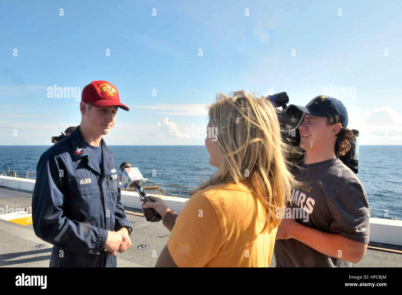 Damage Controlman 2nd class Gregory Alden is being interviewed by the local media aboard amphibious transport dock ship USS New York (LPD 21). New York is transferring to Naval Station Mayport, Fla., as part of a larger move of an amphibious ready group home port change in support of strategic maritime dispersal. (U.S. Navy photo by Mass Communication Specialist 3rd class Angus Beckles/Released) Media cover USS New York move to Mayport 131205-N-GC472-299 Stock Photo