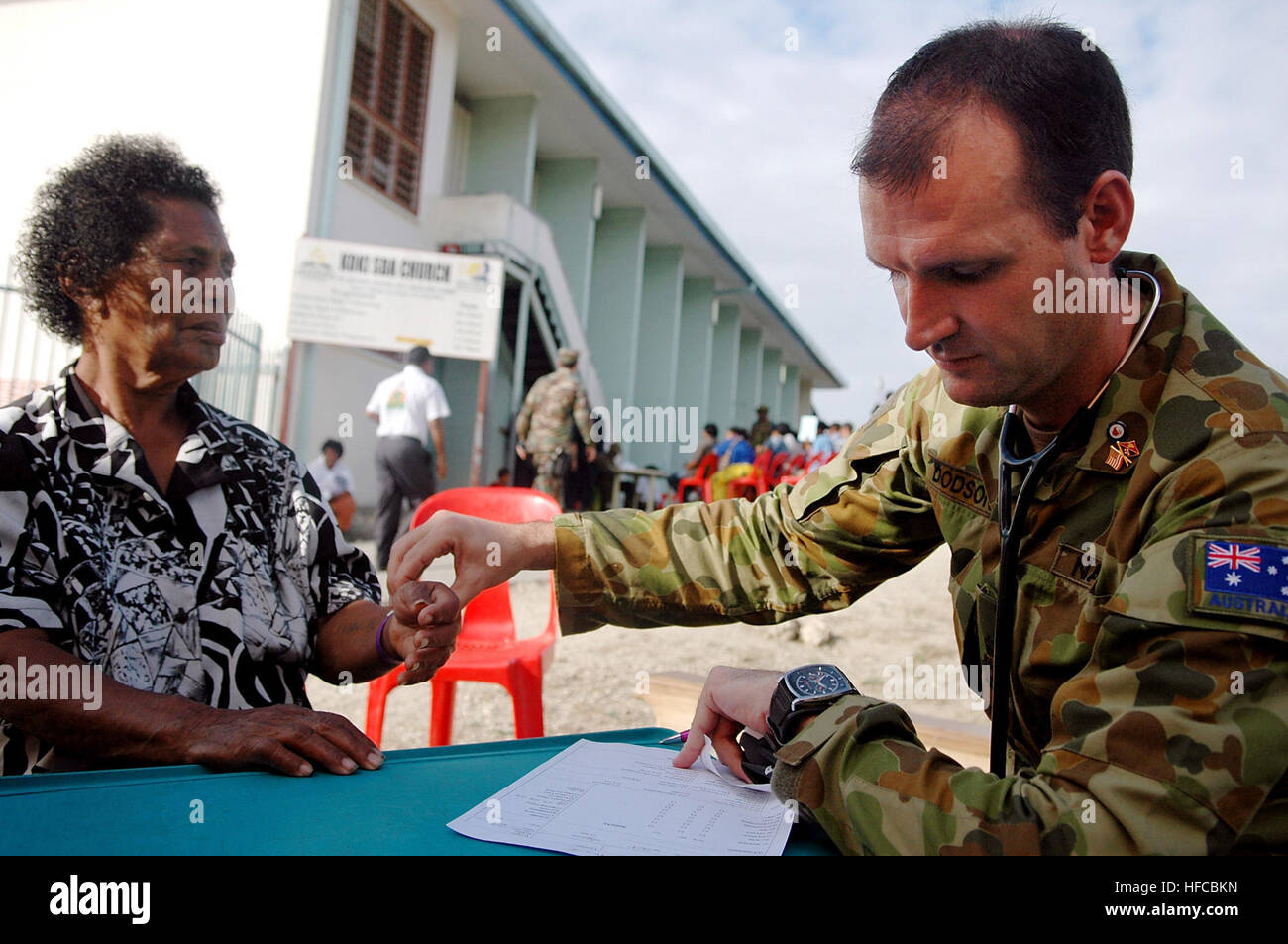 Australian Royal navy Chief Petty Officer Dave Dodson checks the vital signs of a patient during a Pacific Partnership 2008 medical civic action program at Koki Seventh Day Adventist Church. The Military Sealift Command hospital ship USNS Mercy is the main platform for Pacific Partnership and has embarked a multinational group of medical and engineering professionals from military and non-governmental organizations to provide humanitarian assistance to several countries within the Pacific region. Medical Civic Action Program held at Koki Seventh Day Adventist Church 108506 Stock Photo