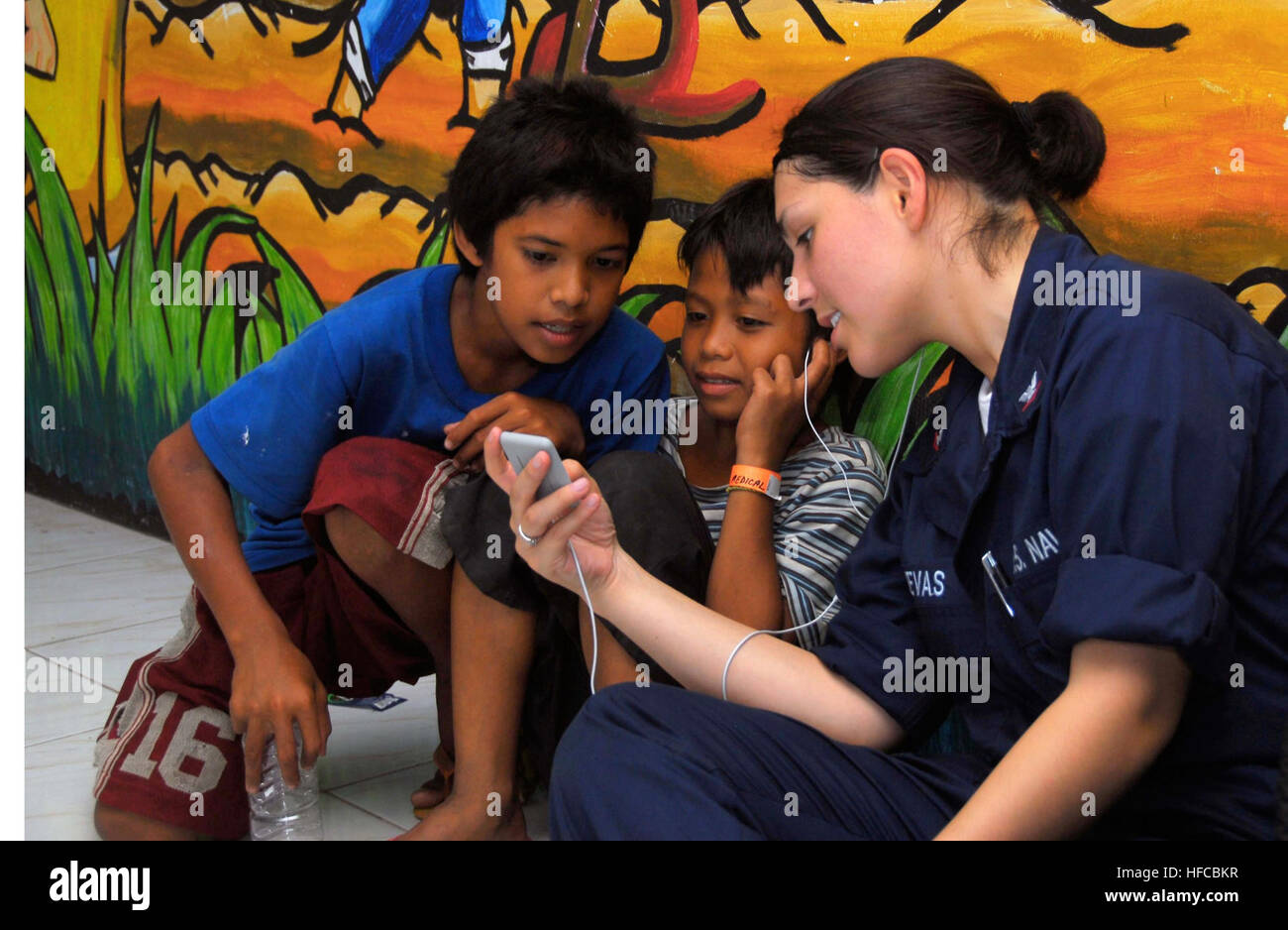 080531-N-9689V-003 PHILIPPINES (May 31, 2008) Information Systems Technician 3rd Class Thania Cuevas, assigned to the Military Sealift Command USNS Mercy (T-AH 19), shares music on her iPod with Filipino children at a Medical Civil Action Program site at the Cotabato City Central Pilot School supporting Pacific Partnership 2008. U.S. Navy photo by Mass Communication Specialist 3rd Class Joshua Valcarcel (Released) Medical Civil Action Program in The Philippines 93737 Stock Photo