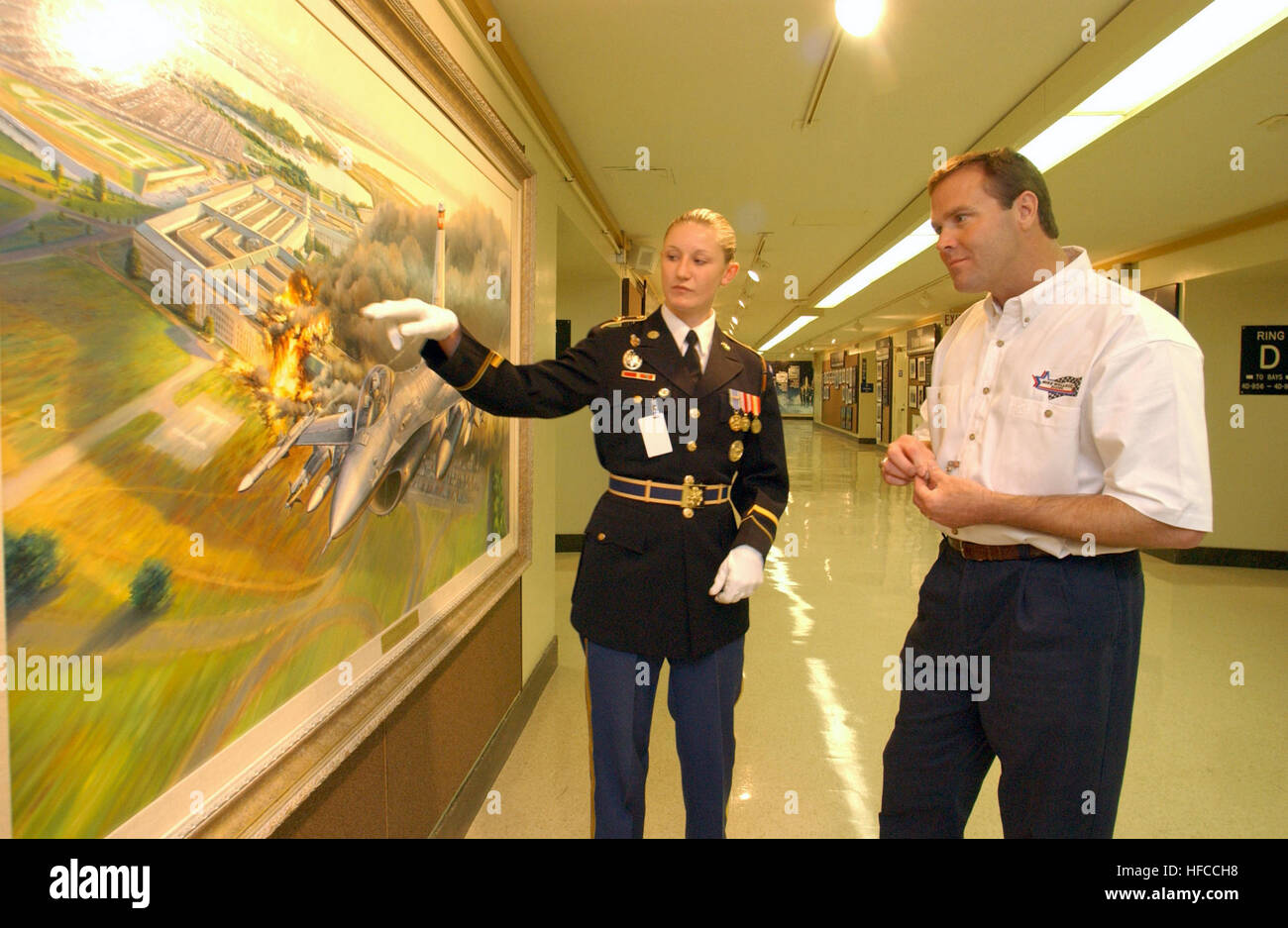021105-N-2383B-533 Pentagon, Arlington, Va. (Nov. 5, 2002) -- U.S. Army Honor Guard, Specialist Camille Adams, a Pentagon tour guide, shows visiting NASCAR race driver Mike Wallace a new painting depicting the first fighter aircraft responding to the attack on the Pentagon, September 11, 2001.  Mike Wallace flew in from North Carolina to spend a day visiting with members of the U.S. Armed Forces, as a gesture of his support for the military.  U.S. Navy photo by Chief Photographer's Mate Johnny Bivera.  (RELEASED) Mike Wallace Pentagon Stock Photo