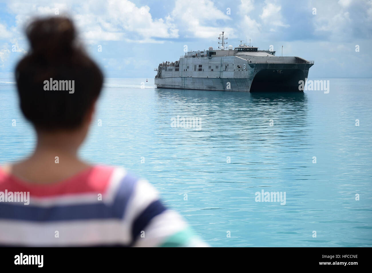150602-N-HY254-015 TARAWA, Kiribati (June 2, 2015) An I-Kiribati girl watches as the Military Sealift Command joint high-speed vessel USNS Millinocket (JHSV 3) arrives in Tarawa, Republic of Kiribati in support of Pacific Partnership 2015.  Tarawa is an atoll and the capital of the Republic of Kiribati, in the central Pacific Ocean and is the first country Millinocket will visit during PP15.  Now in its tenth iteration, Pacific Partnership is the largest annual multilateral humanitarian assistance and disaster relief preparedness mission conducted in the Indio-Asia-Pacific region. While traini Stock Photo