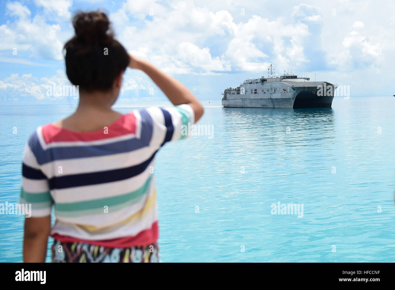150602-N-HY254-017 TARAWA, Kiribati (June 2, 2015) An I-Kiribati girl watches as the Military Sealift Command joint high-speed vessel USNS Millinocket (JHSV 3) arrives in Tarawa, Republic of Kiribati in support of Pacific Partnership 2015.  Tarawa is an atoll and the capital of the Republic of Kiribati, in the central Pacific Ocean and is the first country Millinocket will visit during PP15.  Now in its tenth iteration, Pacific Partnership is the largest annual multilateral humanitarian assistance and disaster relief preparedness mission conducted in the Indio-Asia-Pacific region. While traini Stock Photo