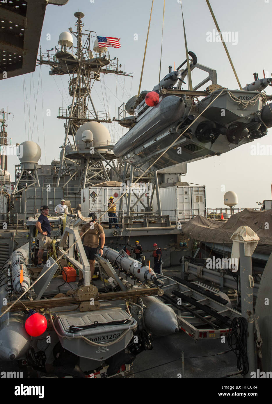 Sailors and civilian contractors with Task Group 56.1 use a crane to ...