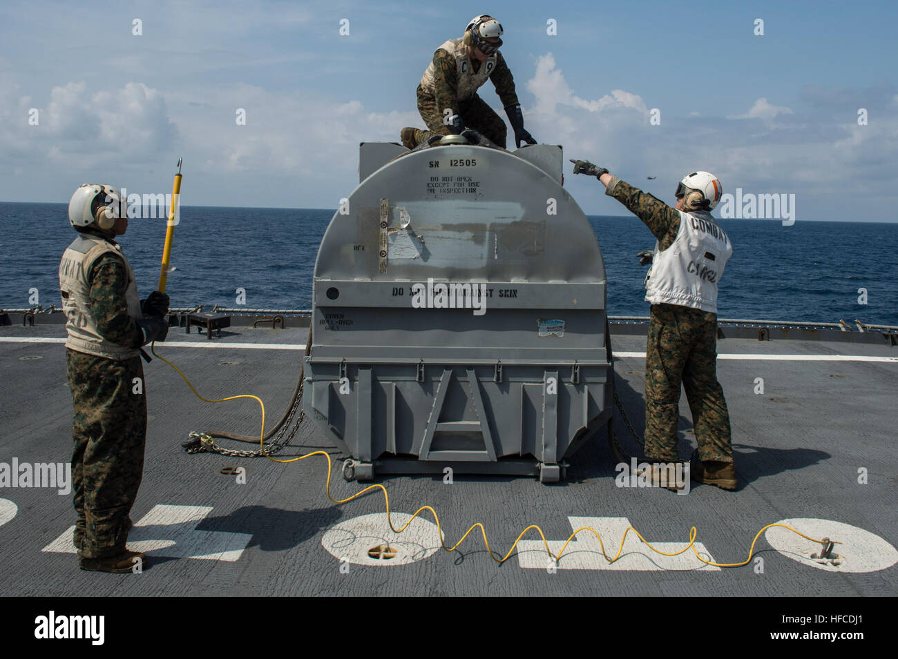 131115-N-JP249-185 ARABIAN SEA (Nov. 15, 2013) Aboard the Military Sealift Command fleet replenishment oiler USNS Laramie (T-AO 203), Marines prepare an aircraft engine for transport to the amphibious assault ship USS Boxer (LHD 4). Boxer is the flagship for the Boxer Amphibious Ready Group and, with the embarked 13th Marine Expeditionary Unit, is deployed in support of maritime security operations and theater security cooperation efforts in the U.S. 5th Fleet area of responsibility. (U.S. Navy photo by Mass Communication Specialist 2nd Class Kenan O’Connor/Released) Moving an aircraft engine  Stock Photo