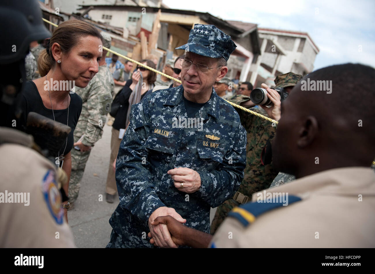 Navy Adm. Mike Mullen, chairman of the Joint Chiefs of Staff greets Port Au Prince, Haiti, police during a walking tour of the devastated downtown area on Feb. 26. Mullen in Haiti 255154 Stock Photo