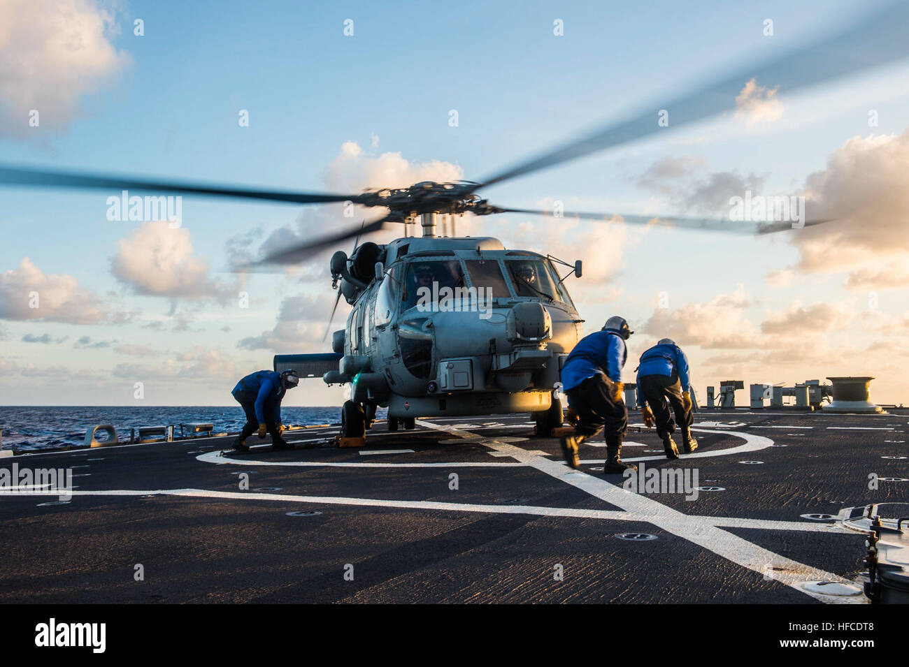 150325-N-XM324-034 WATERS NEAR GUAM (March 25, 2015) Sailors prepare to remove chocks and chains from an MH-60R Seahawk of Helicopter Maritime Strike Squadron (HSM) 51 as it prepares to depart from the flight deck of the Arleigh Burke-class guided missile destroyer USS Fitzgerald (DG 62) during Multi-Sail 2015. Multi-Sail is an annual Destroyer Squadron 15 exercise designed to assess combat systems, improve teamwork and increase warfighting capabilities in the Seventh Fleet area of responsibility. Japan Maritime Self-Defense Force (JMSDF) is participating in Multi-Sail for the first time to im Stock Photo