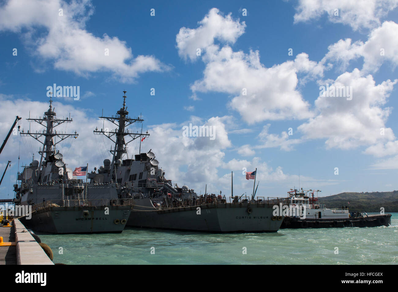 APRA HARBOR, Guam (March 4, 2016) – The destroyer USS Curtis Wilbur (DDG-54), gets tugged next to USS McCampbell (DDG-85) at Apra Harbor, U.S. Naval Base Guam, for a short in-port period prior to the bilateral exercise Multi-Sail 2016 (MS-16). Ten total naval surface combatants assigned to the U.S. and Japanese navies arrived in-port to Apra Harbor, increasing the total number of visiting and home-ported vessels at the base to 20 and marked the largest contingent of vessels in Apra Harbor in more than 30 years. (Released/Jeff Landis, Major, USMC (Ret.), Director of Public Affairs/Communication Stock Photo