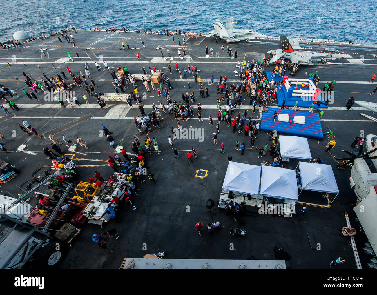 Sailors relax during a steel beach picnic on the flight deck of the Nimitz-class aircraft carrier USS Carl Vinson (CVN 70). Carl Vinson is deployed in the U.S. 5th Fleet area of operations supporting Operation Inherent Resolve, strike operations in Iraq and Syria as directed, maritime security operations, and theater security cooperation efforts in the region. (U.S. Navy photo by Mass Communication Specialist 2nd Class Alex King/Released) Operation Inherent Resolve 141102-N-WD464-113 Stock Photo