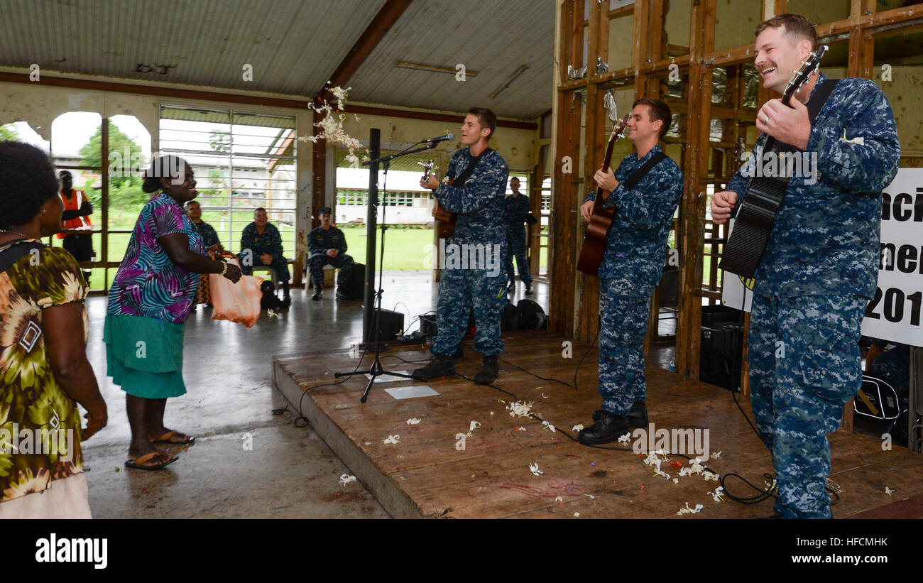 ARAWA, Autonomous Region of Bougainville, Papua New Guinea (June 30, 2015) Women throw flowers for members of the Pacific Fleet Band during a concert for children at the Arawa Primary School as part of Pacific Partnership 2015. The hospital ship USNS Mercy (T-AH 19) is in Papua New Guinea for its second mission port of PP15. Pacific Partnership is in its tenth iteration and is the largest annual multilateral humanitarian assistance and disaster relief preparedness mission conducted in the Indo-Asia-Pacific region. While training for crisis conditions, Pacific Partnership missions to date have  Stock Photo