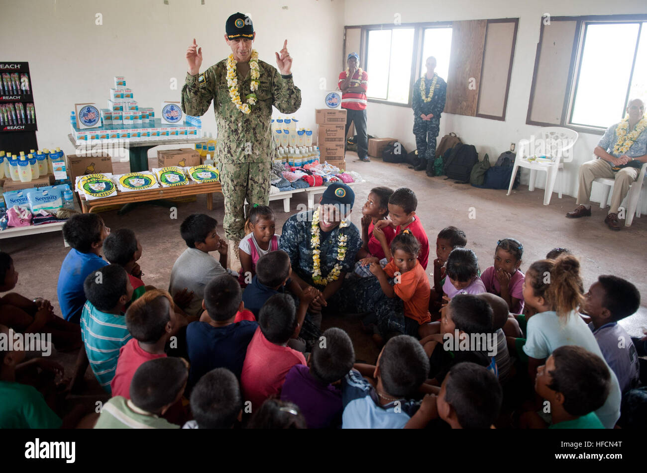 Capt. Wallace Lovely, mission commander of Pacific Partnership 2013, leads children in a chant during a Pacific Partnership community service event to donate clothing and first-aid supplies. Working at the invitation of each host nation, Pacific Partnership is joined by partner nations that include Australia, Canada, Colombia, France, Japan, Malaysia, Singapore, South Korea and New Zealand to strengthen disaster response preparedness around the Indo-Asia-Pacific region. (U.S. Navy photo by Mass Communication Specialist 2nd Class Tim D. Godbee/Released) Pacific Partnership 2013 130709-N-SK590-5 Stock Photo