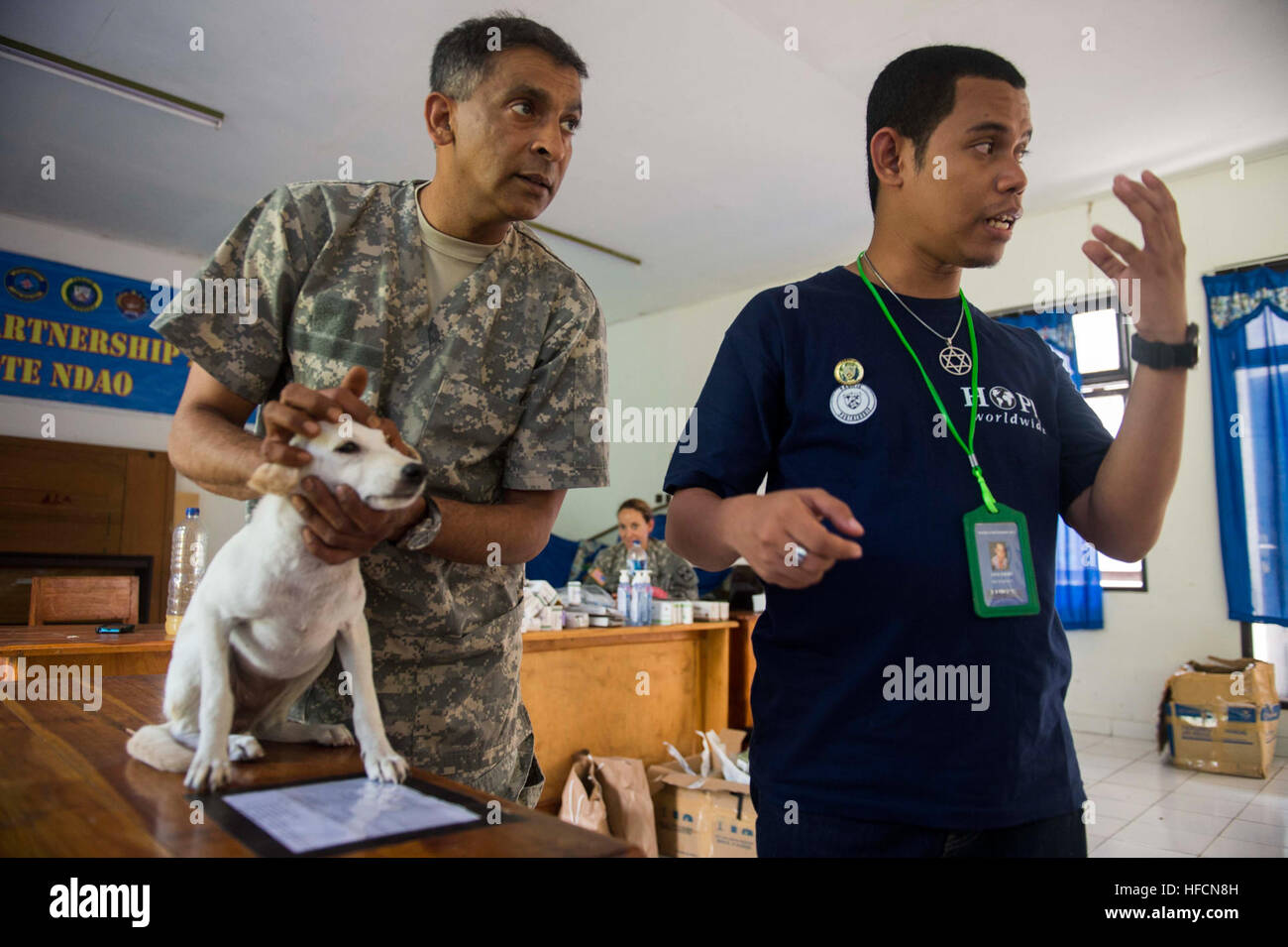 140602-N-IL267-101 BA'A, Indonesia (June 2, 2014) U.S. Army Maj. Raghavan Sampathkumaran, a veterinarian from Lompoc, Calif., assigned to the 109th Medical Detachment Veterinary Services, peforms a pre-surgery physical examination on a dog while Jack Loloin, a volunteer interpreter from Hope Worldwide, translates for Indonesian animal doctors and veterinarian medics as part of a veterinarian subject matter expert exchange at Dinas Peternakan Rote Ndao veterinarian clinic in Ba'a, Indonesia, during Pacific Partnership 2014. Pacific Partnership is in its ninth iteration and is the largest annual Stock Photo