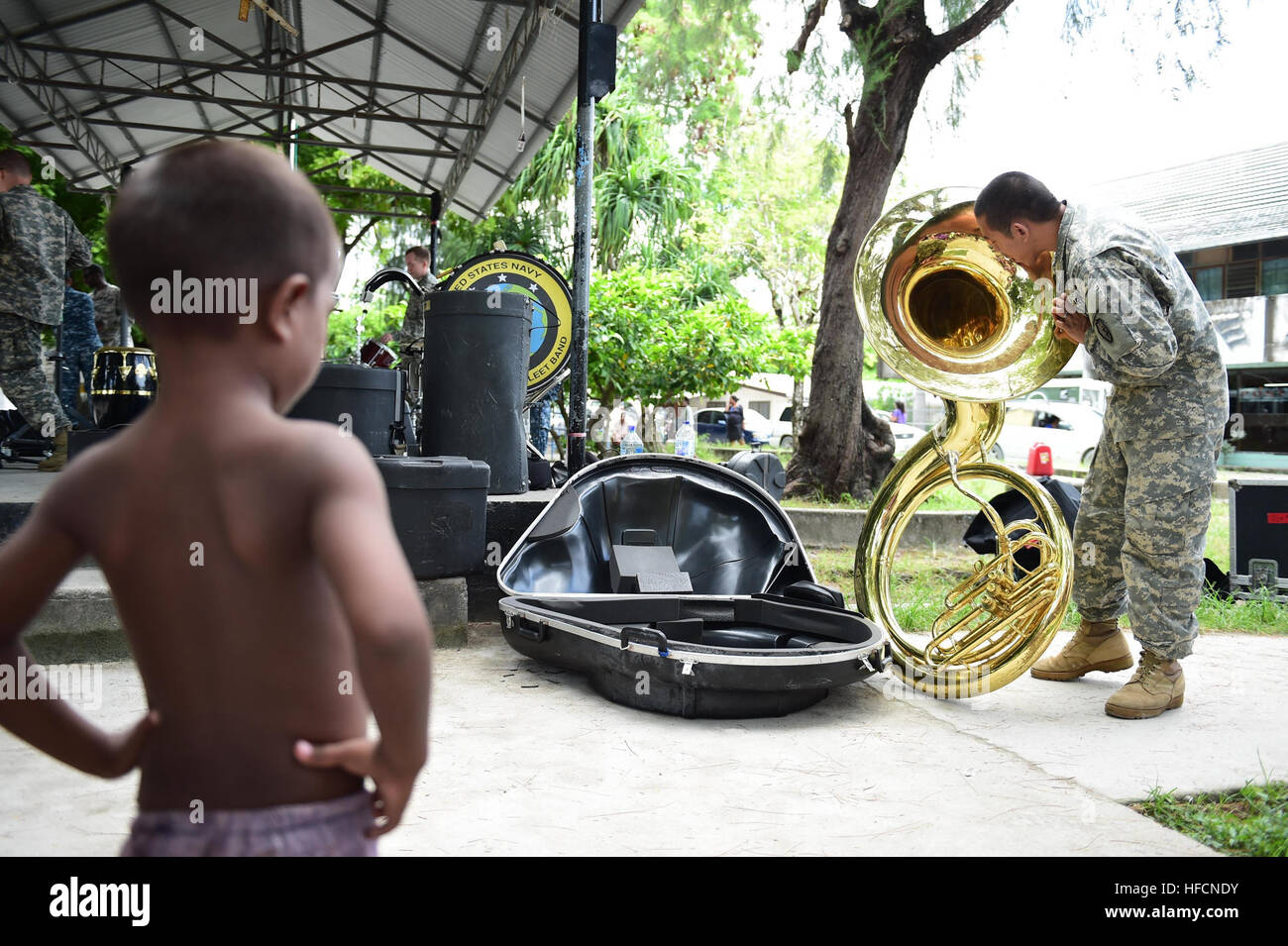150604-N-HY254-022 TARAWA, Kiribati (June 4, 2015) An I-Kiribati boy watches a member of the 25th Infantry Division Band prepare his tuba for a concert in Bairiki Square during a Pacific Partnership visit to the Independent Republic of Kiribati. Joint High Speed Vessel USNS Millinocket (JHSV 3) is serving as the secondary platform for Pacific Partnership, led by an expeditionary command element from the Navy’s 30th Naval Construction Regiment (30 NCR) from Port Hueneme, Calif. Now in its 10th iteration, Pacific Partnership is the largest annual multilateral humanitarian assistance and disaster Stock Photo