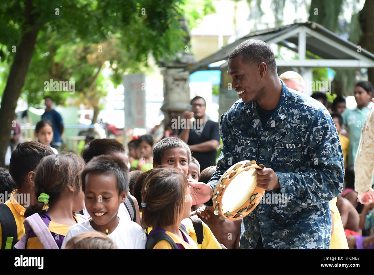 150604-N-HY254-204 TARAWA, Kiribati (June 4, 2015) Petty Officer 3rd Class Brian Mathis, a musician with the U.S. Pacific Fleet Band, plays tambourine with a group of kids at a concert held in Bairiki Square during a Pacific Partnership visit to the Independent Republic of Kiribati. Joint High Speed Vessel USNS Millinocket (JHSV 3) is serving as the secondary platform for Pacific Partnership, led by an expeditionary command element from the Navy’s 30th Naval Construction Regiment (30 NCR) from Port Hueneme, Calif. Now in its 10th iteration, Pacific Partnership is the largest annual multilatera Stock Photo