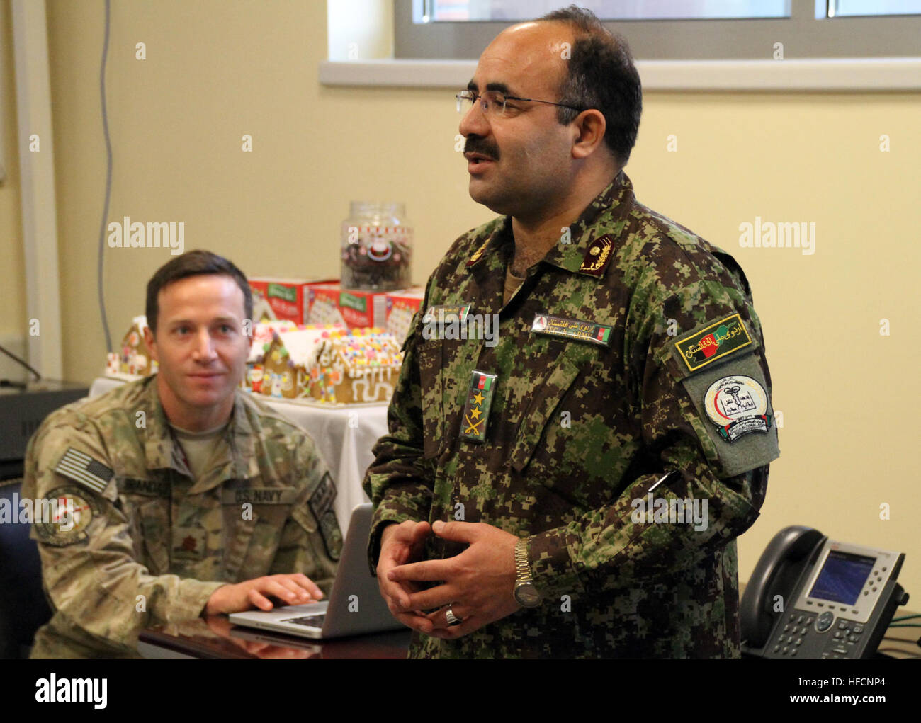 Dr. Mohammad Sadiq Wardak, chief of Surgery at Kandahar Regional Medical Hospital, talks with staff at the NATO Role 3 Multinational Medical Unit in Kandahar, Afghanistan. Partnerships at the NATO Role 3 Multinational Medical Unit 141222-N-JY715-346 Stock Photo